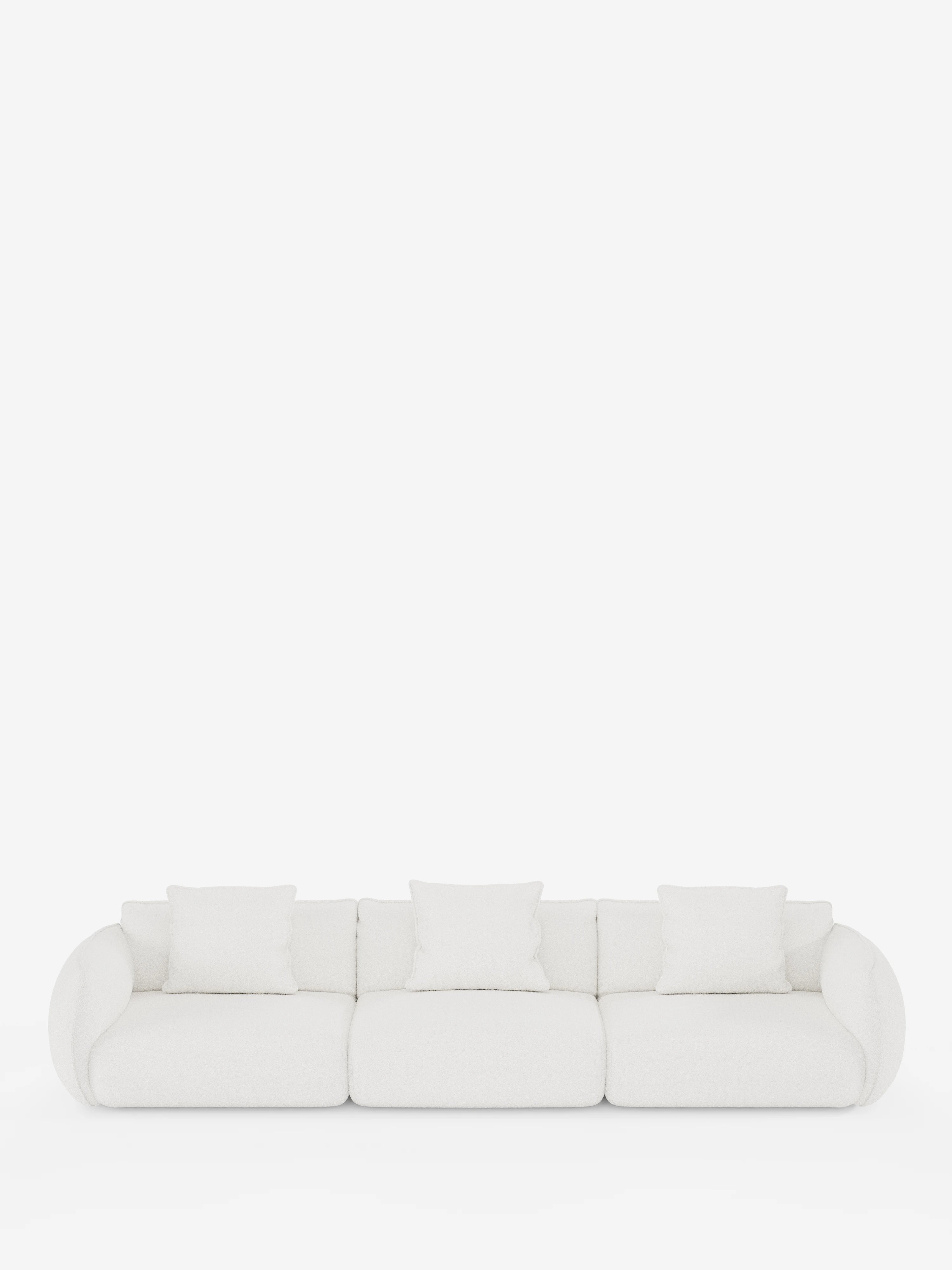 Un moderno divano modulare bianco Nimbus a 3 posti di Divani.Store, caratterizzato da braccioli arrotondati, tre sezioni di seduta e quattro cuscini quadrati bianchi in morbido tessuto T33 effetto cotone, resistente alle macchie. Su uno sfondo bianco a tinta unita, il suo design minimalista e pulito crea un’atmosfera contemporanea e ariosa.