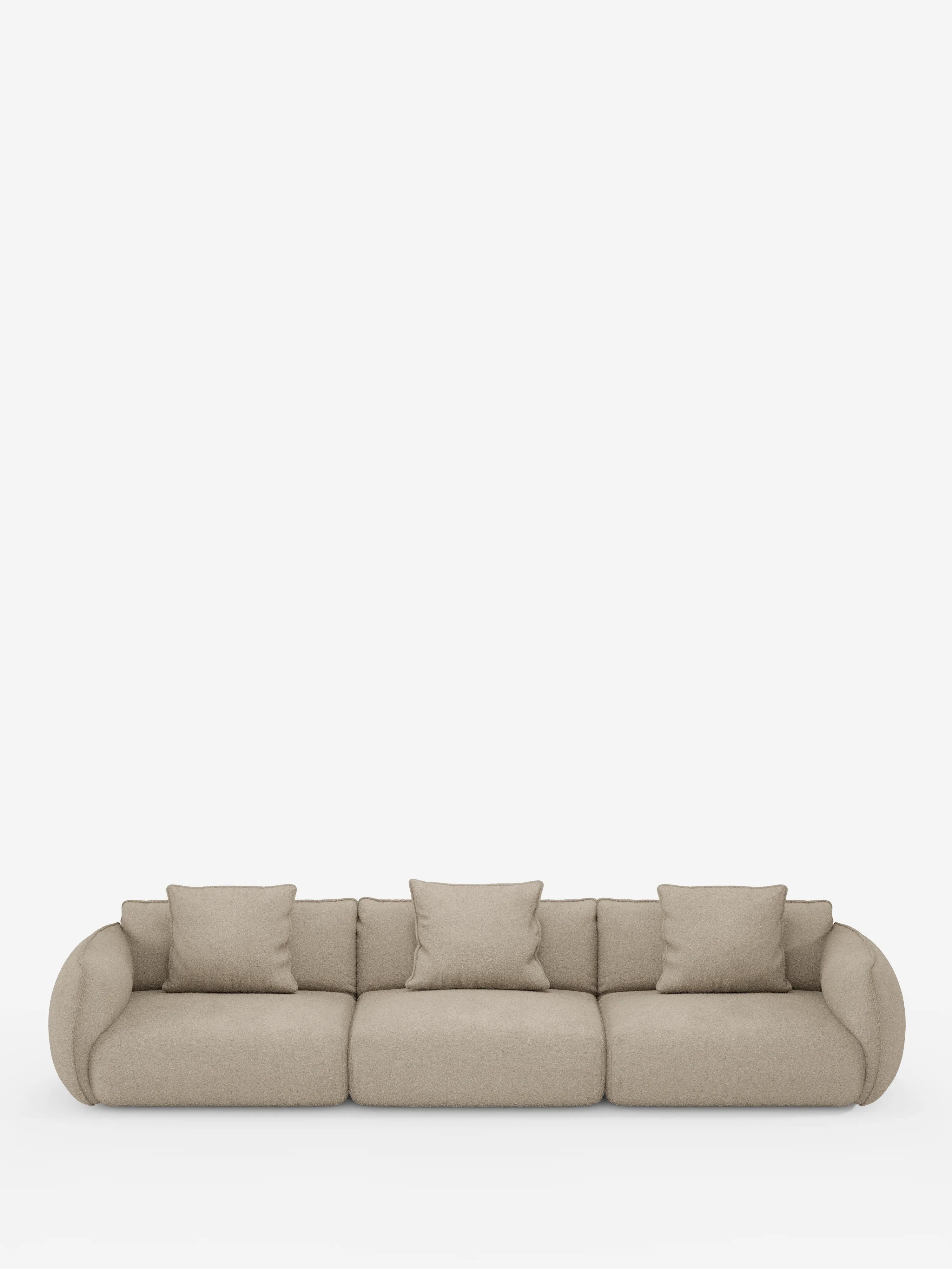 Un moderno divano modulare a 3 posti Nimbus di Divani.Store, rivestito in morbido tessuto effetto cotone T33 resistente alle macchie, color beige, presenta tre ampie sedute, braccioli arrotondati e quattro cuscini quadrati coordinati. Il design minimalista presenta un rivestimento liscio senza gambe a vista e si staglia su uno sfondo bianco a tinta unita.