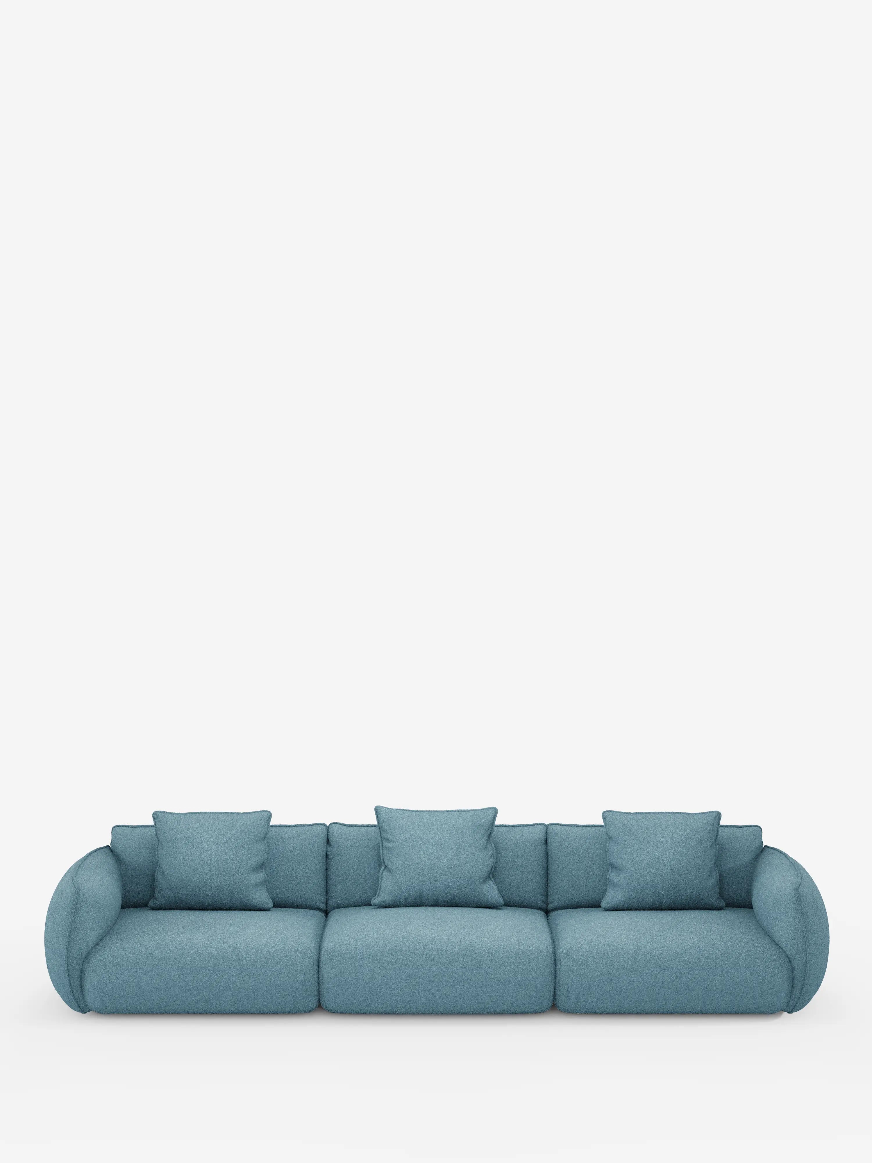 Un moderno divano modulare Nimbus blu a 3 posti di Divani.Store, rivestito in morbido tessuto effetto cotone resistente alle macchie (T33), dotato di tre cuscini di seduta e tre cuscini quadrati coordinati. Il divano presenta braccioli arrotondati ed è raffigurato su uno sfondo bianco a tinta unita con ampio spazio libero sopra di esso.