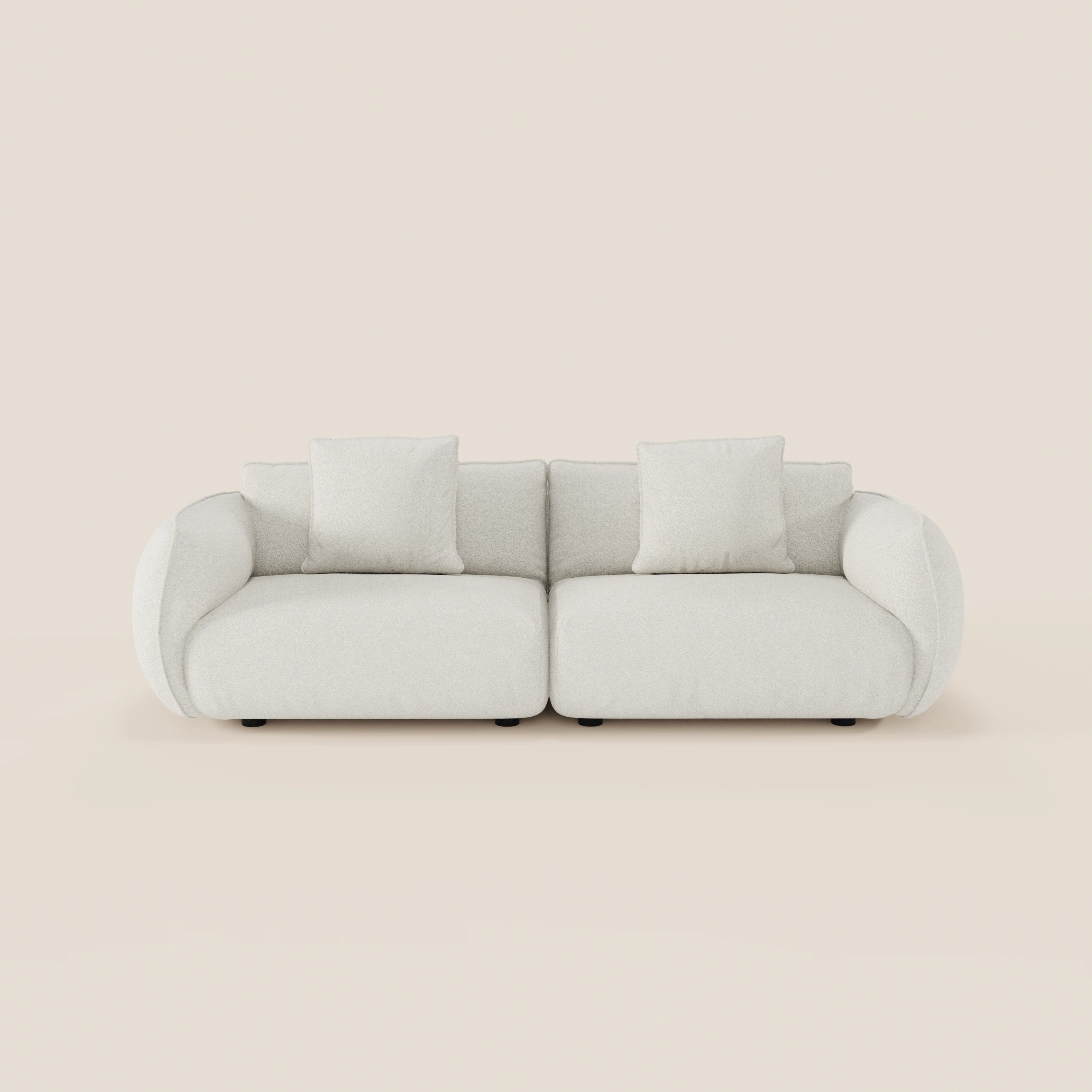Il divano Nimbus 3 posti modulare e componibile di Divani.Store, in tessuto smacchiabile effetto cotone, è caratterizzato da un design moderno e arrotondato di colore bianco con braccioli e tre cuscini quadrati, su uno sfondo beige chiaro.