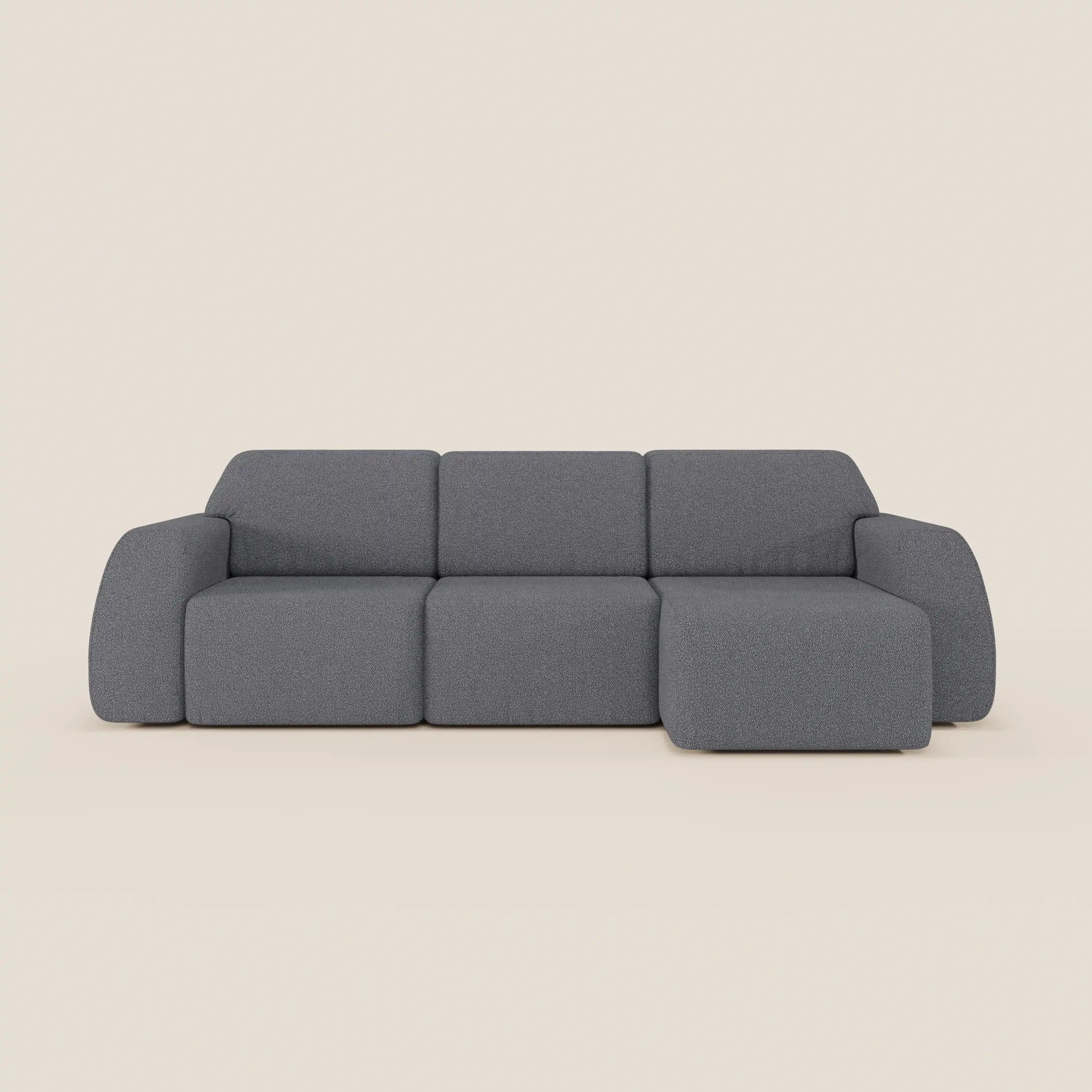 Il divano angolare Orbit con penisola reversibile di Divani.Store, in tessuto smacchiabile effetto cotone T33 grigio, presenta tre sedute allungabili, braccioli arrotondati e profilo basso su sfondo beige chiaro.