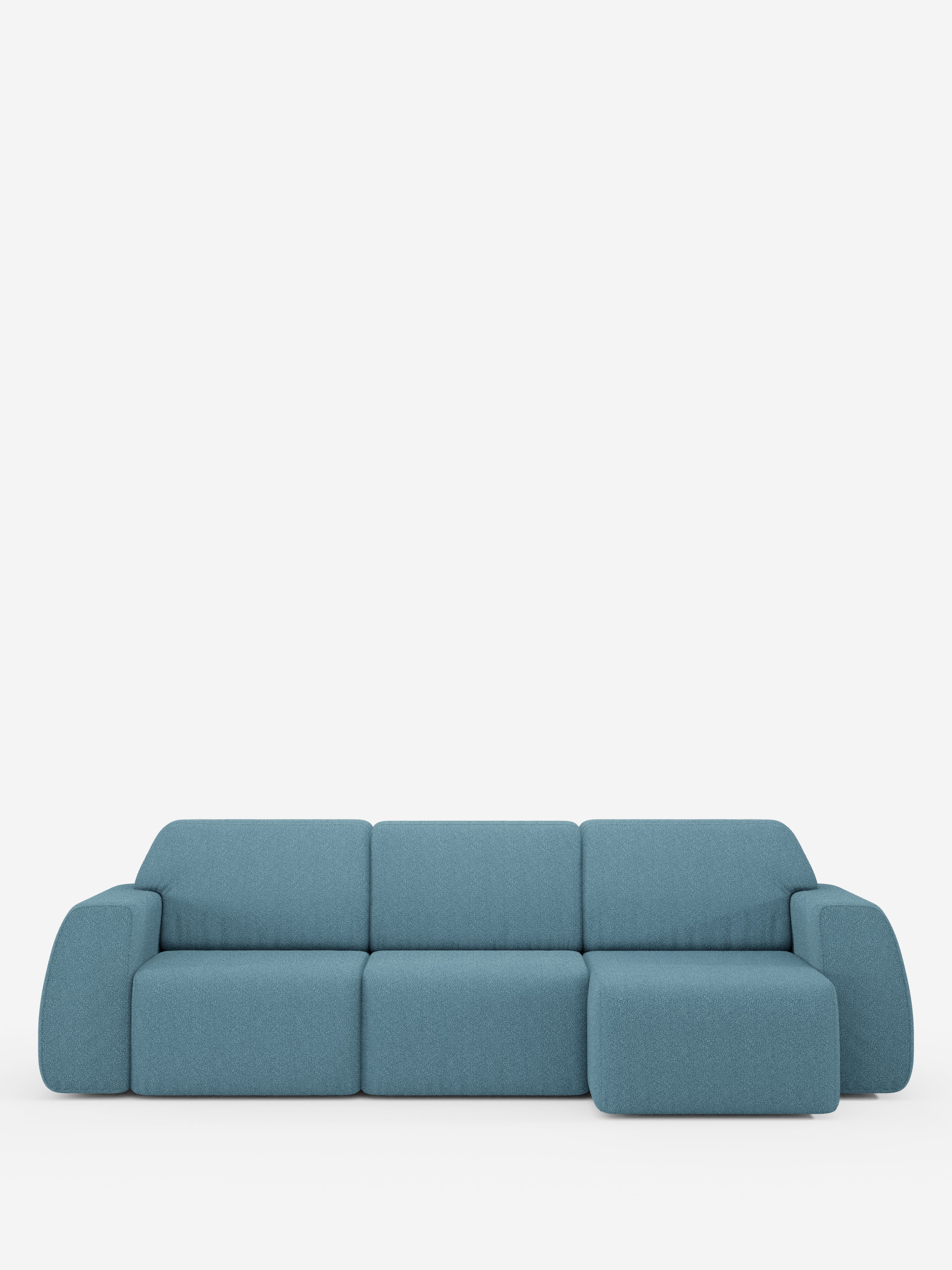Un moderno divano componibile blu “Orbit” di Divani.Store, caratterizzato da una chaise longue reversibile e da sedute allungabili. Questo divano di alta gamma presenta morbidi braccioli arrotondati e un design minimalista, realizzato in tessuto effetto cotone antimacchia (T33), qui raffigurato su uno sfondo bianco a tinta unita.
