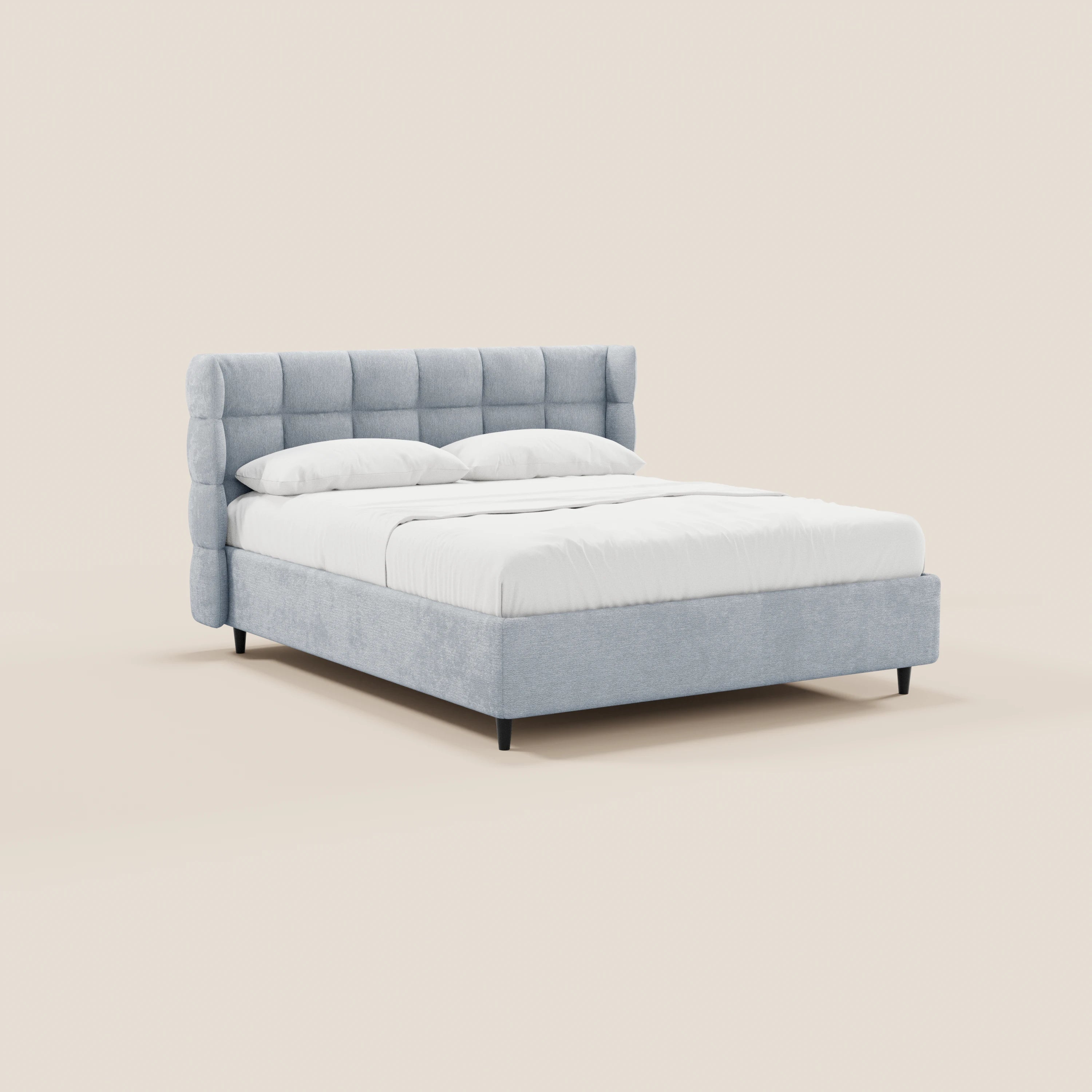 Il letto imbottito RAGNAR di Letti.store, realizzato in tessuto grigio chiaro certificato Oeko-Tex® con testiera avvolgente capitonné e gambe nere, è raffigurato ben rifatto con biancheria da letto bianca su uno sfondo beige a tinta unita. Non sono visibili altri mobili o elementi decorativi.