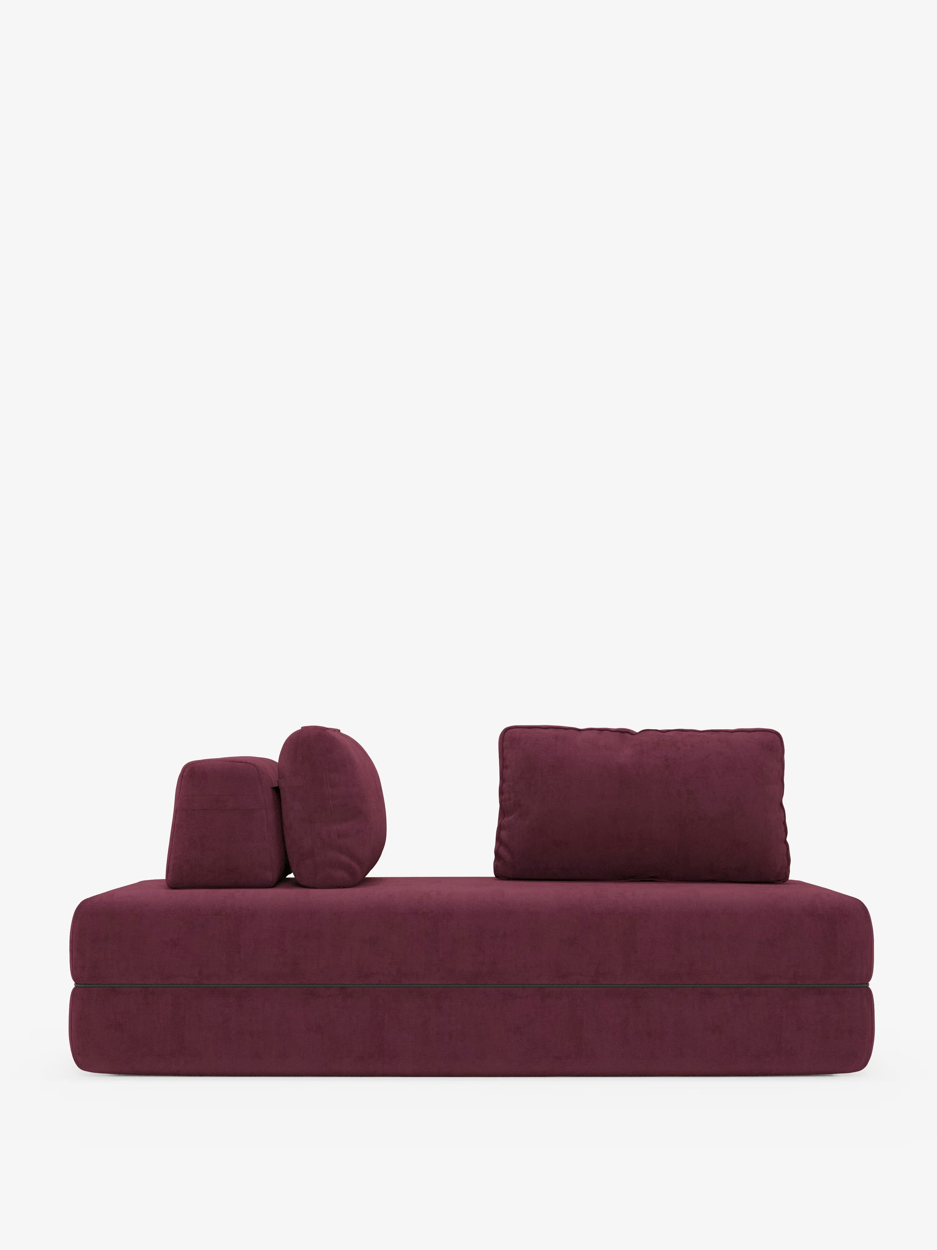 Un divano letto matrimoniale moderno e minimalista della linea Rift, disponibile nelle versioni a 2 e 3 posti con schienali mobili, realizzato da Divani.Store, caratterizzato da un materasso in memory foam alto 24 cm e da un rivestimento in tessuto T31 antimacchia, si staglia su uno sfondo bianco a tinta unita. Due cuscini rettangolari (schienali mobili) sono posizionati ai lati sinistro e destro, accompagnati da due cuscini cilindrici coordinati.