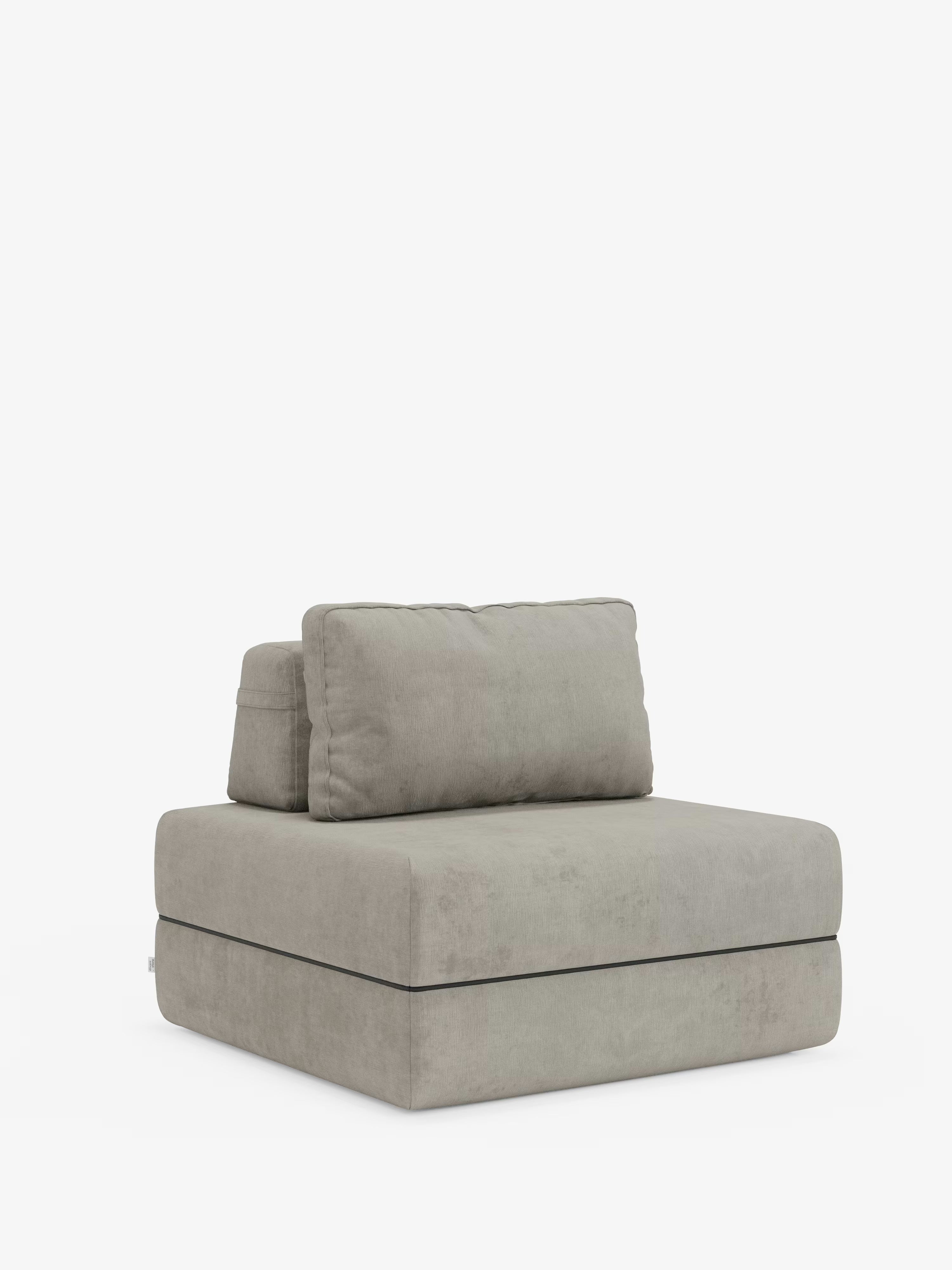 Una moderna poltrona letto Rift di Divani.Store, in grigio chiaro, rivestita in tessuto T31 antimacchia e dotata di un materasso in memory foam alto 24 cm e di uno schienale regolabile, spicca su uno sfondo bianco. Linee pulite, una silhouette squadrata e le cuciture a vista sui bordi conferiscono a questa poltrona senza braccioli un fascino minimalista e contemporaneo: una scelta innovativa per chi è alla ricerca di un design eccezionale per la propria poltrona letto da inserire nei propri spazi abitativi.