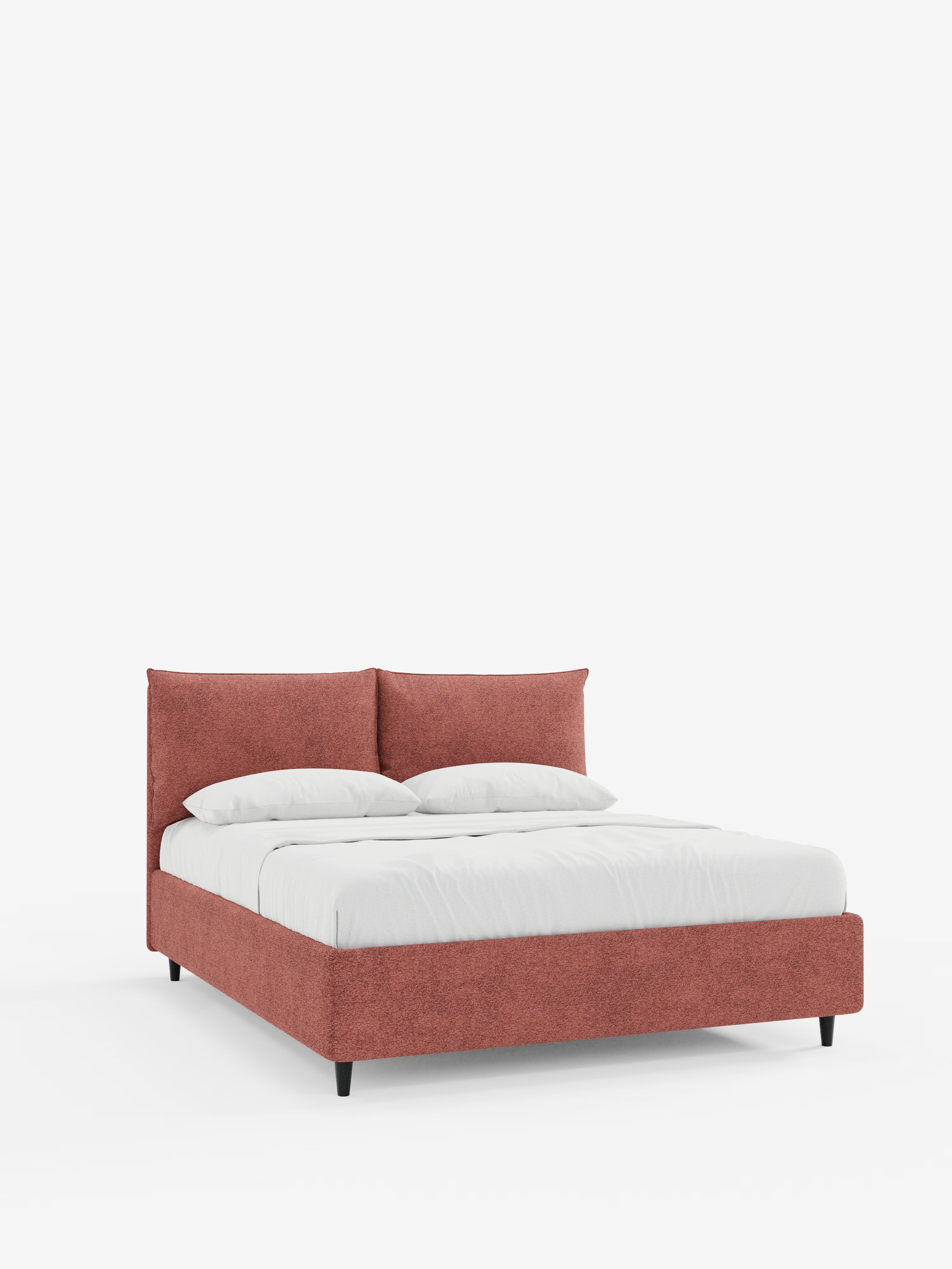 Un moderno letto imbottito ZAYRON con contenitore di Letti.store, caratterizzato da una struttura in tessuto dai toni rossastri certificato Oeko-Tex®, morbidi cuscini regolabili per la testiera, gambe basse nere e biancheria da letto bianca con due cuscini e un piumone, il tutto su uno sfondo bianco a tinta unita.