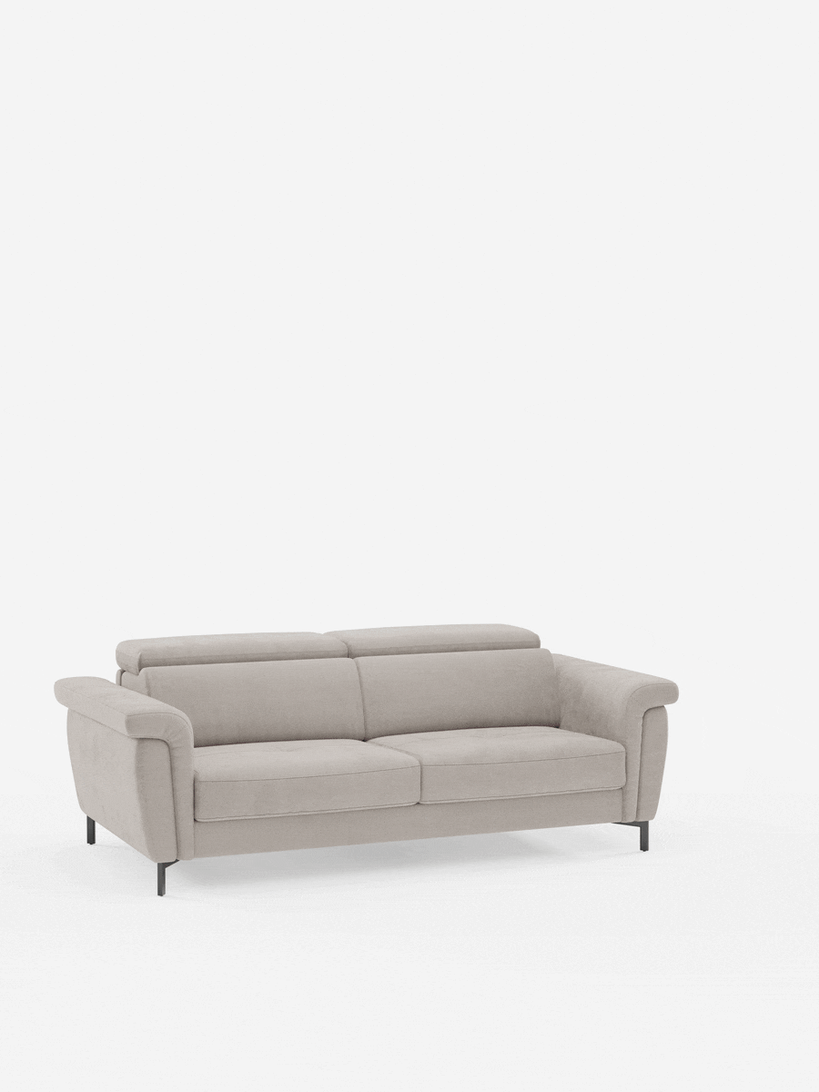Un divano beige chiaro, il divano letto di design Capri di Divani.Store, caratterizzato da braccioli squadrati, sedute imbottite e poggiatesta regolabili. Realizzato con maestria nella manifattura italiana con un raffinato tessuto effetto velluto T30 resistente alle macchie, questo divano letto vanta sottili gambe alte nere e una silhouette moderna. Sullo sfondo di un bianco semplice, le sue linee eleganti risaltano magnificamente.
