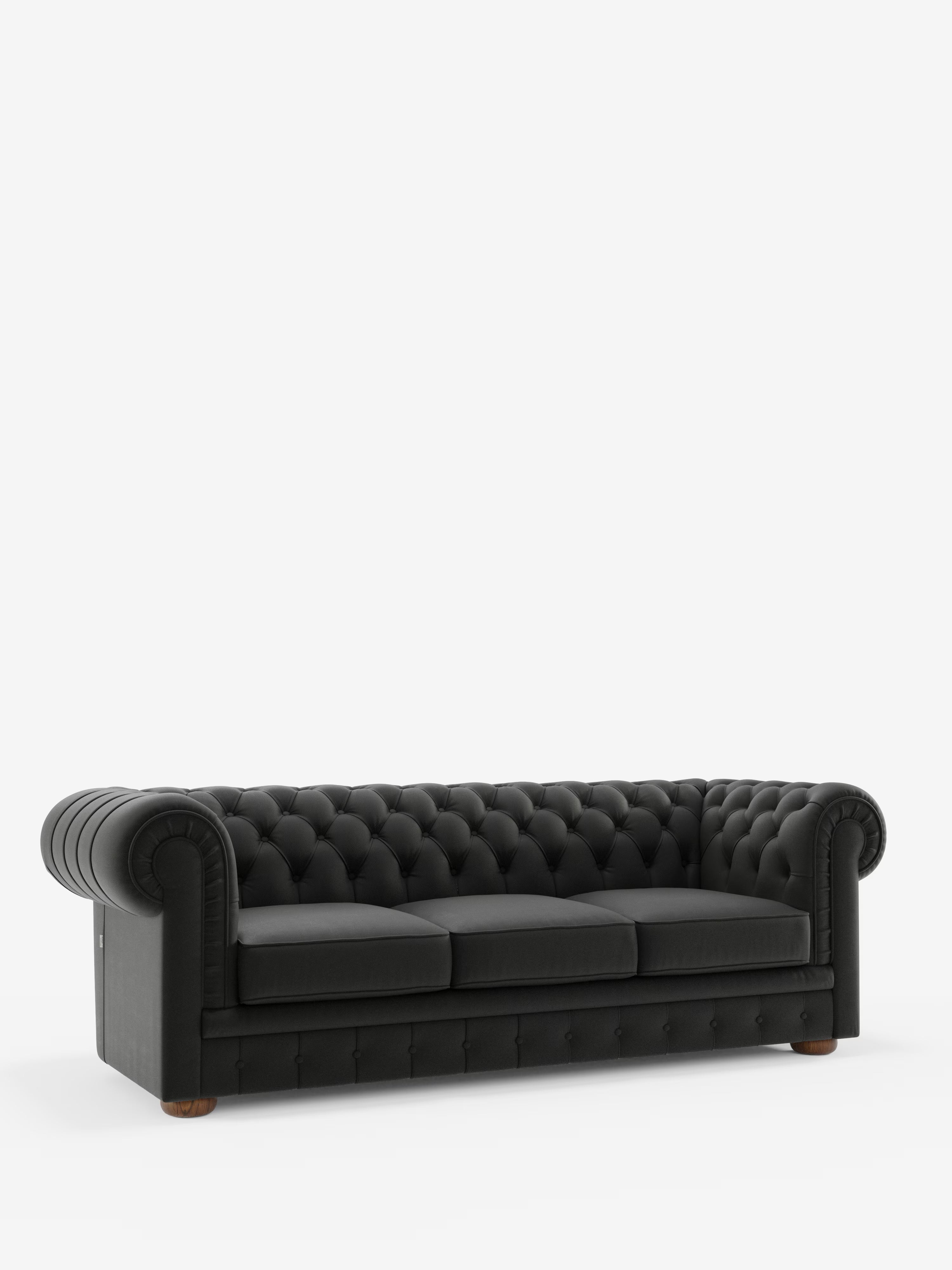Un divano Chester a 4 posti con 3 sedute in vera pelle – Chesterfield capitonné artigianale di Divani.Store, in elegante pelle nera con raffinata lavorazione artigianale capitonné, braccioli arrotondati e tre ampie sedute, poggia su piedini corti in legno su uno sfondo bianco.