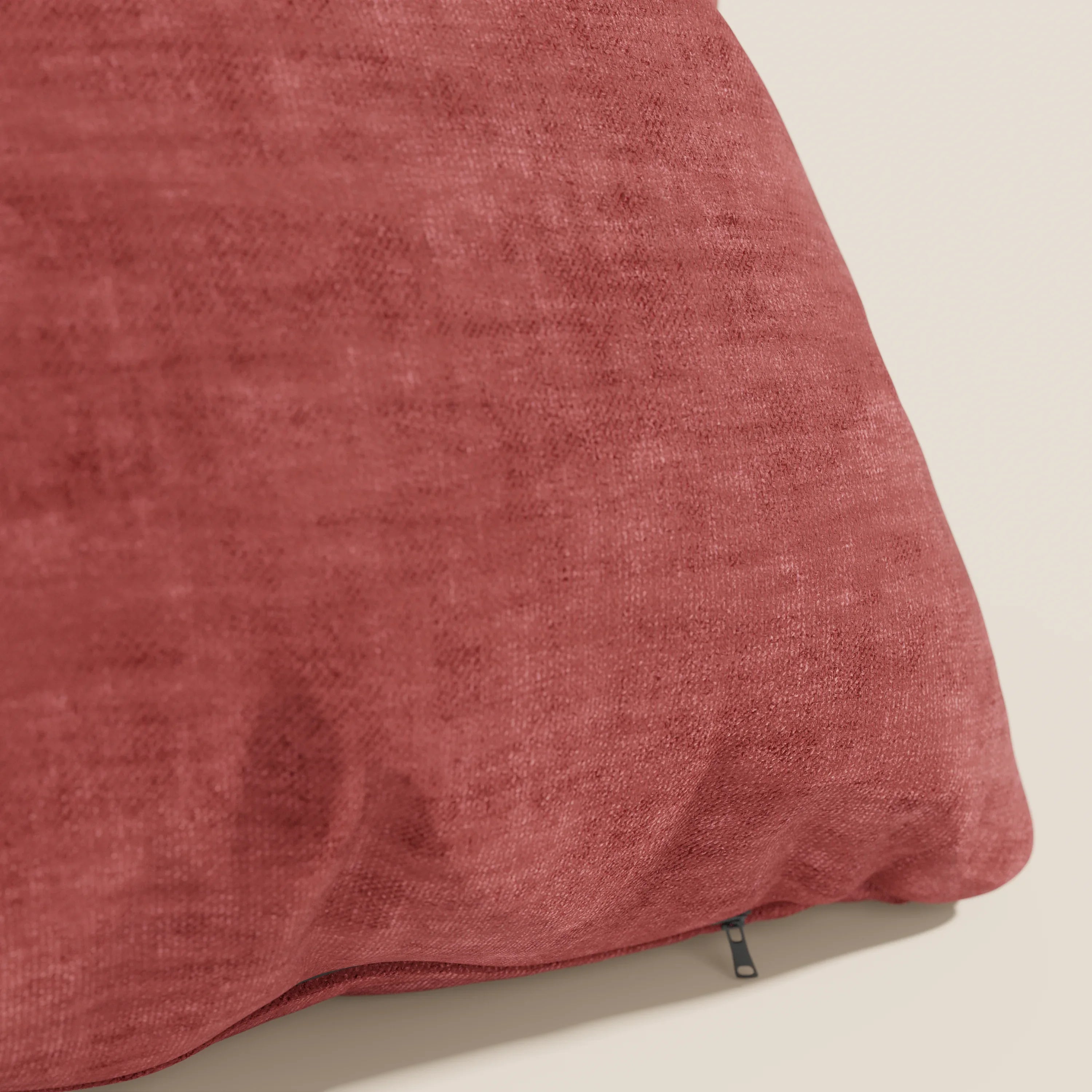 Primo piano del cuscino Sofia di Divani.Store in rosso intenso, realizzato in morbido velluto Easy Clean T35, antimacchia e impermeabile. Il cuscino decorativo è mostrato su uno sfondo chiaro con un'etichetta in tessuto nero visibile.
