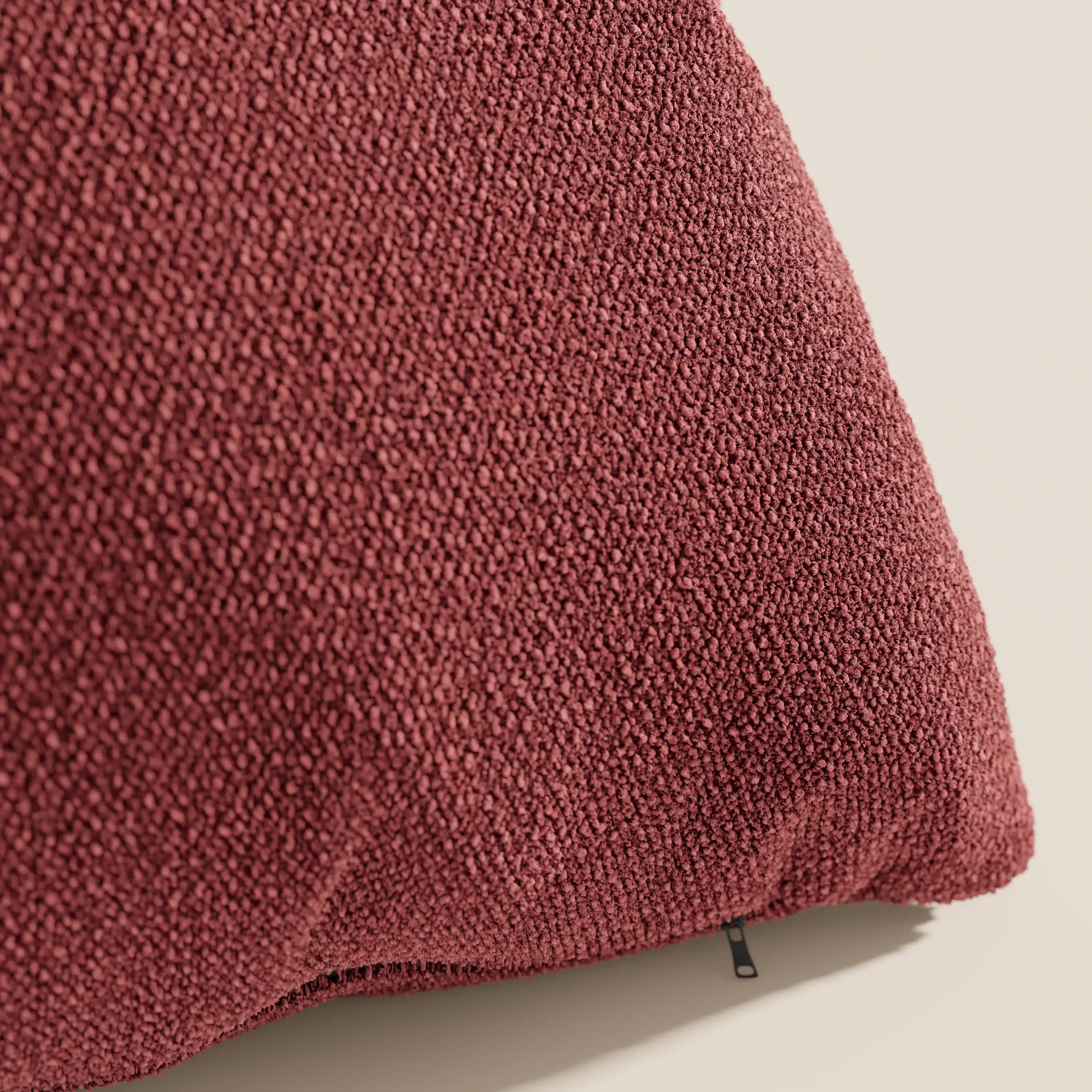 Primo piano del cuscino Lambada bordeaux di Divani.Store, realizzato in tessuto fresco, antimacchia e impermeabile T33 effetto cotone naturale, con cerniera a vista sul bordo inferiore su sfondo beige chiaro.
