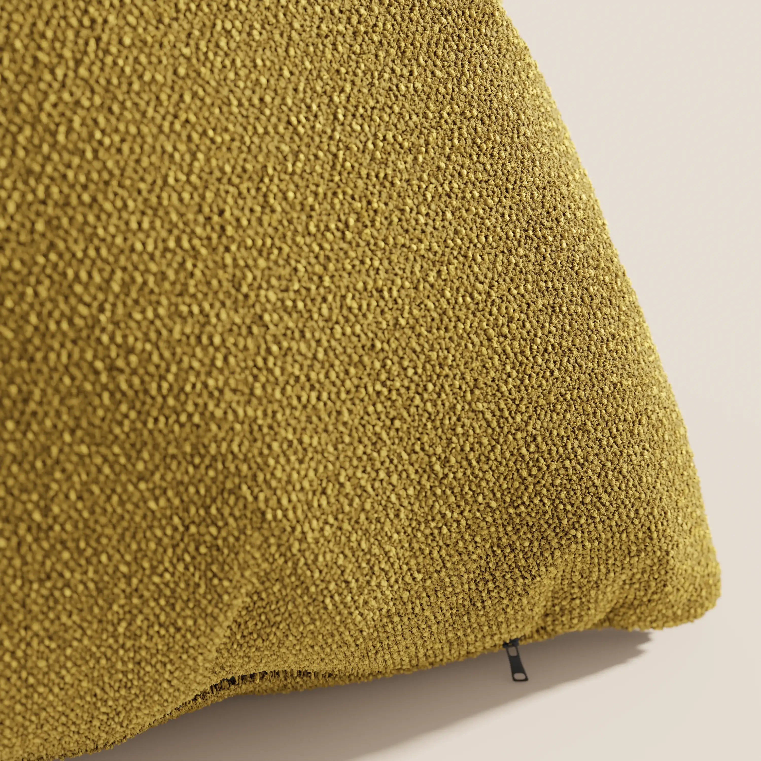 Un primo piano del cuscino Lambada di Divani.Store in giallo senape, realizzato in tessuto T33 lavabile e impermeabile, fresco e simile al cotone, mostra la sua texture intrecciata e la cerniera a vista su uno sfondo neutro.