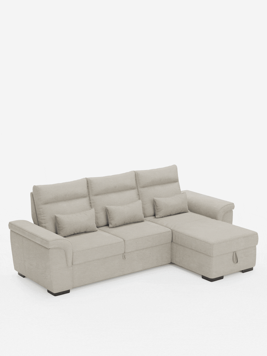 Divano letto angolare Ischia color beige chiaro con tre schienali, tre piccoli cuscini rettangolari, una chaise longue sul lato destro e piedini scuri dal profilo basso, su uno sfondo bianco uniforme.