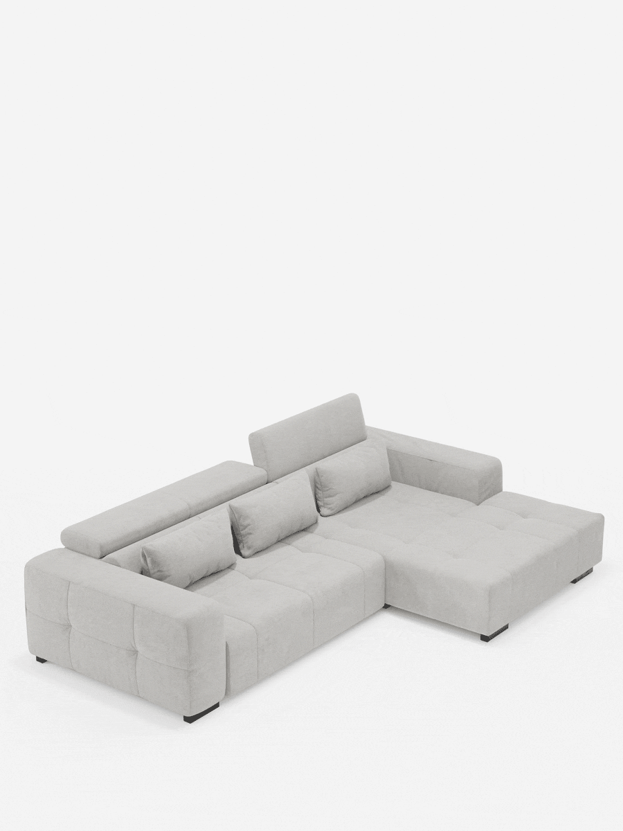 Il divano angolare Monarch con penisola e funzione Relax Elettrico per l’allungamento delle sedute di Divani.Store è un divano componibile a forma di L di colore grigio chiaro, rivestito in morbido tessuto T31 resistente alle macchie, con cuscini trapuntati, braccioli squadrati e poggiatesta reclinabili regolabili. Corredato da due cuscini decorativi abbinati e messo in risalto da uno sfondo bianco a tinta unita, questo divano esalta il suo design contemporaneo e minimalista.