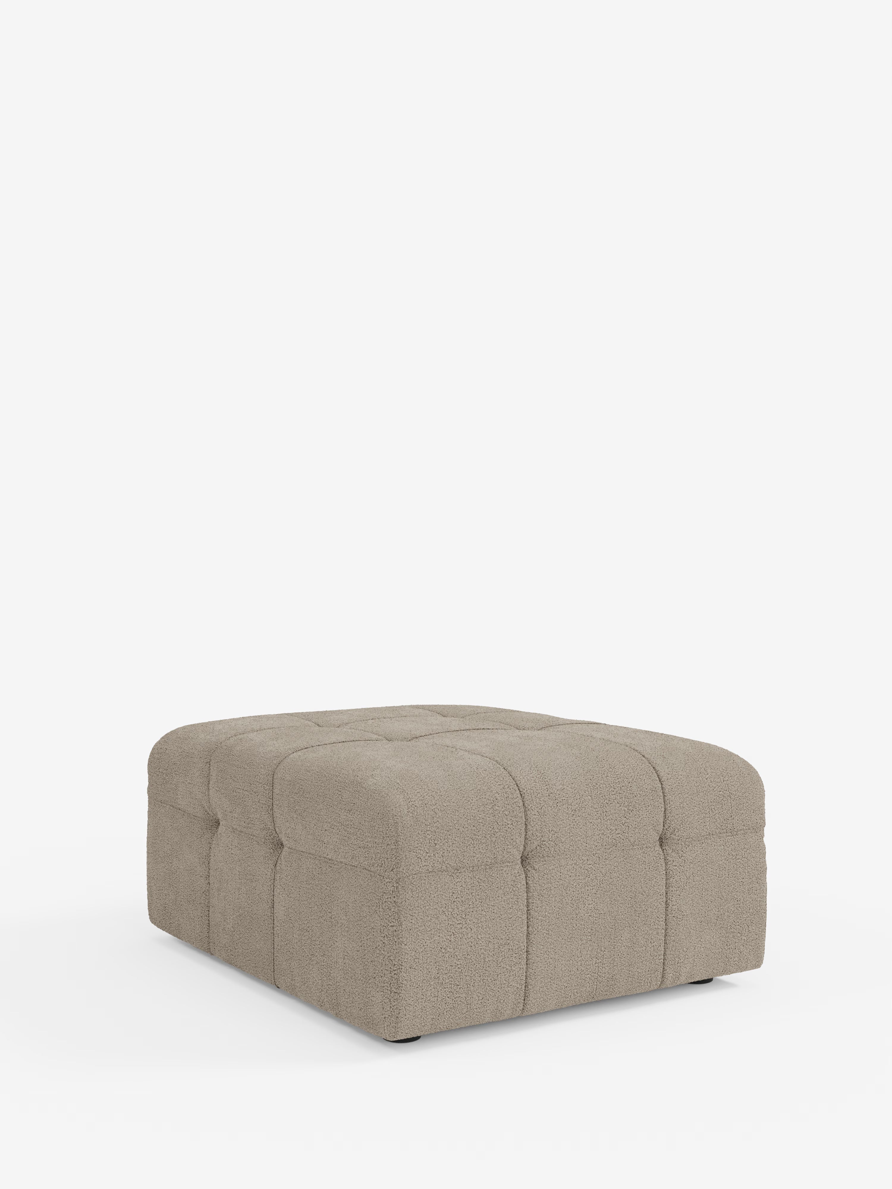 Il pouf e modulo Mosaic in bouclé di Divani.Store è un pouf quadrato color taupe che misura 96x77 cm, realizzato in tessuto T21 resistente alle macchie. Caratterizzato da un design capitonné con una superficie morbida e strutturata e bordi arrotondati, questo elemento d’arredo moderno si distingue su uno sfondo bianco. Le cuciture a vista formano un motivo a griglia sulla parte superiore e sui lati, sottolineandone lo stile contemporaneo.