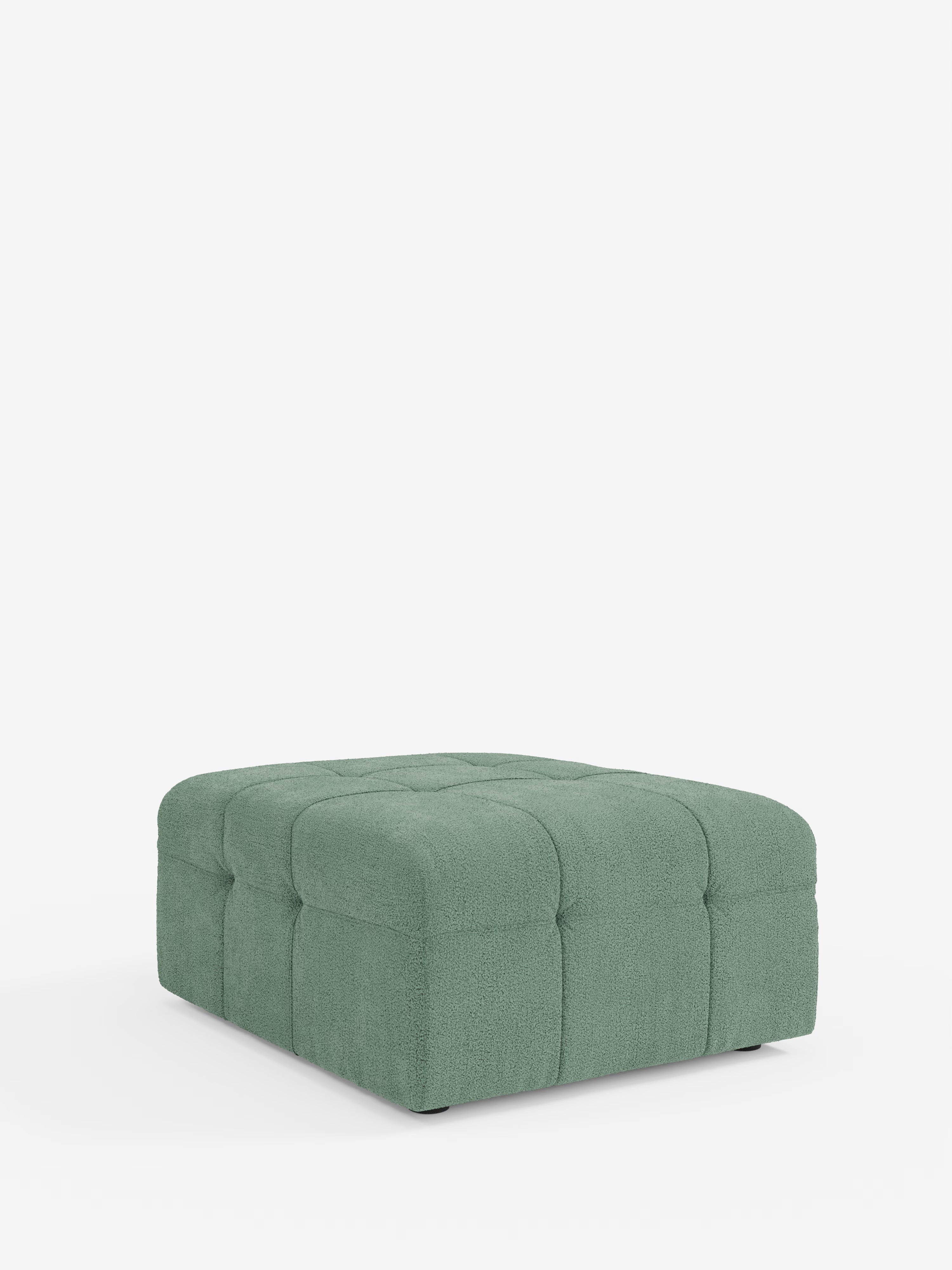Qui viene presentato un pouf quadrato verde della linea Mosaic di Divani.Store, caratterizzato da un design capitonné di 96x77 cm in tessuto bouclé T21 resistente alle macchie. Realizzato con la maestria artigianale italiana e appoggiato direttamente sul pavimento senza gambe visibili, la sua texture lussuosa e le sue finiture eleganti risaltano sullo sfondo bianco a tinta unita, che fa sì che il pouf rimanga il punto focale della stanza.