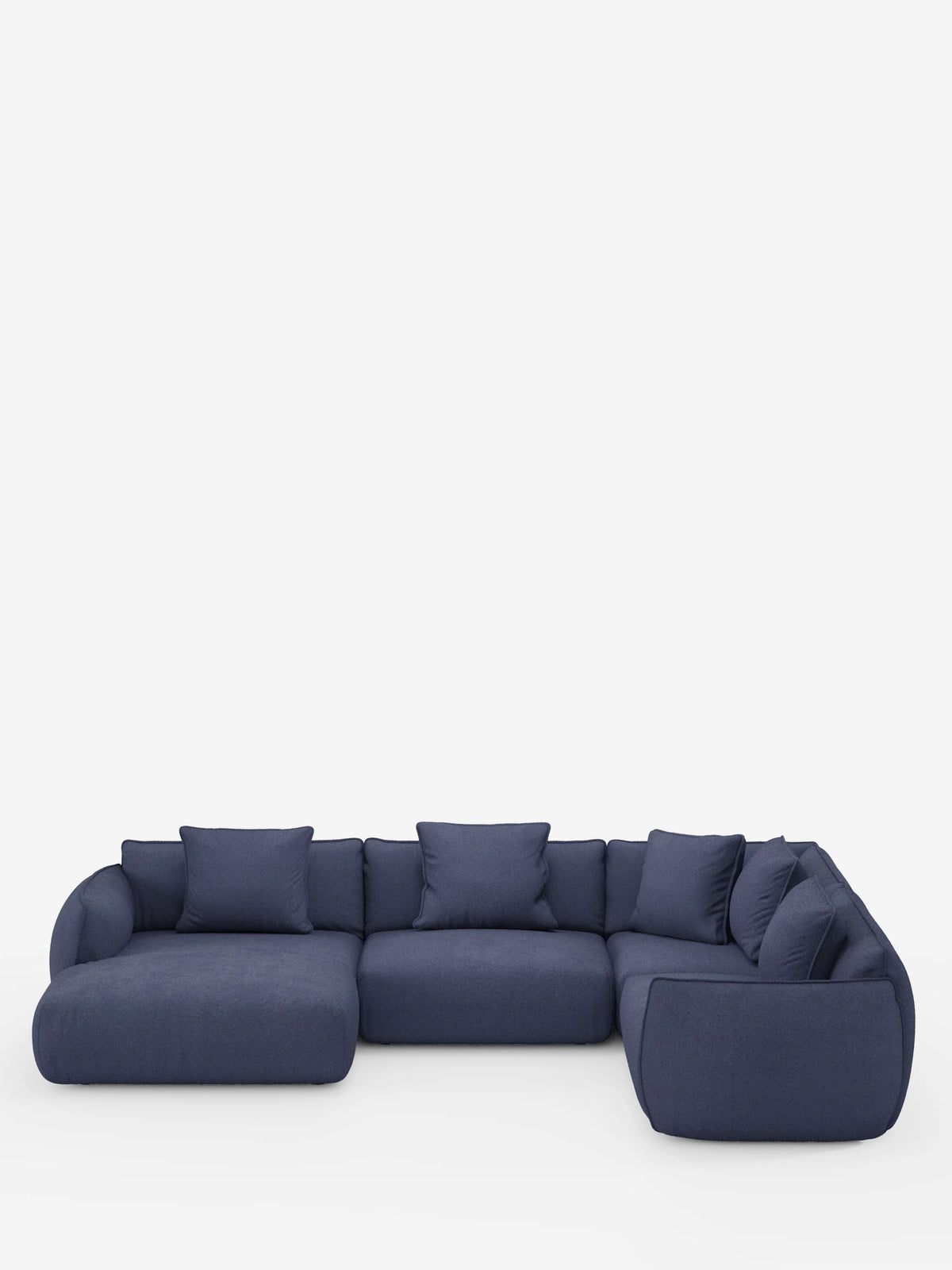 Un moderno divano angolare panoramico componibile Nimbus con penisola e angolo in tessuto smacchiabile T33 di Divani.Store, rivestito in tessuto blu scuro e caratterizzato da ampi cuscini di seduta bassi con sette cuscini dello schienale abbinati, su uno sfondo bianco a tinta unita. Questo divano contemporaneo e lussuoso, di produzione italiana, presenta un design elegante senza gambe a vista.