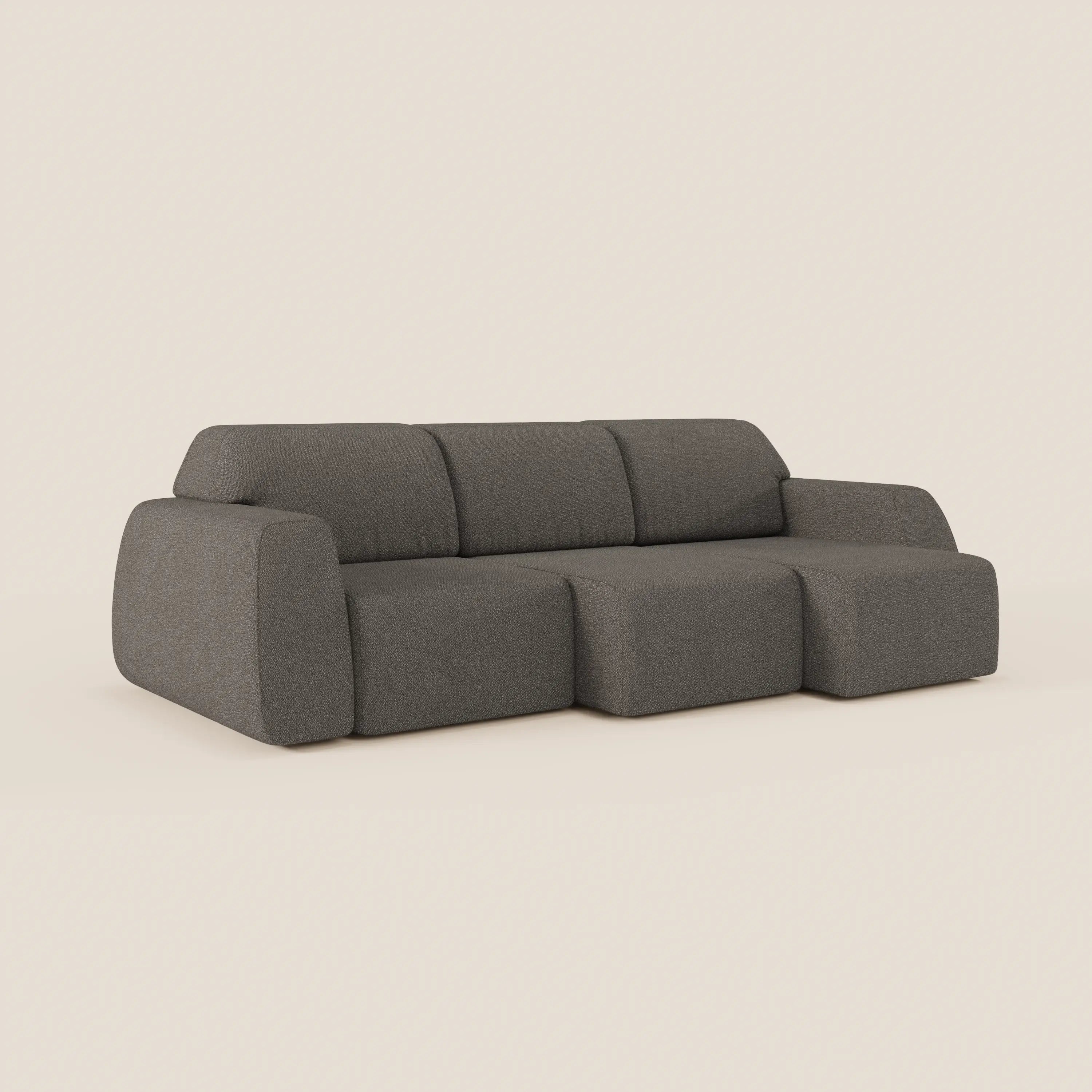 Il divano Orbit con 3 sedute scorrevoli e allungabili in tessuto effetto cotone T33 di Divani.Store, presentato in grigio scuro con cuscini ampi, braccioli massicci e chaise lounge a destra su sfondo beige.