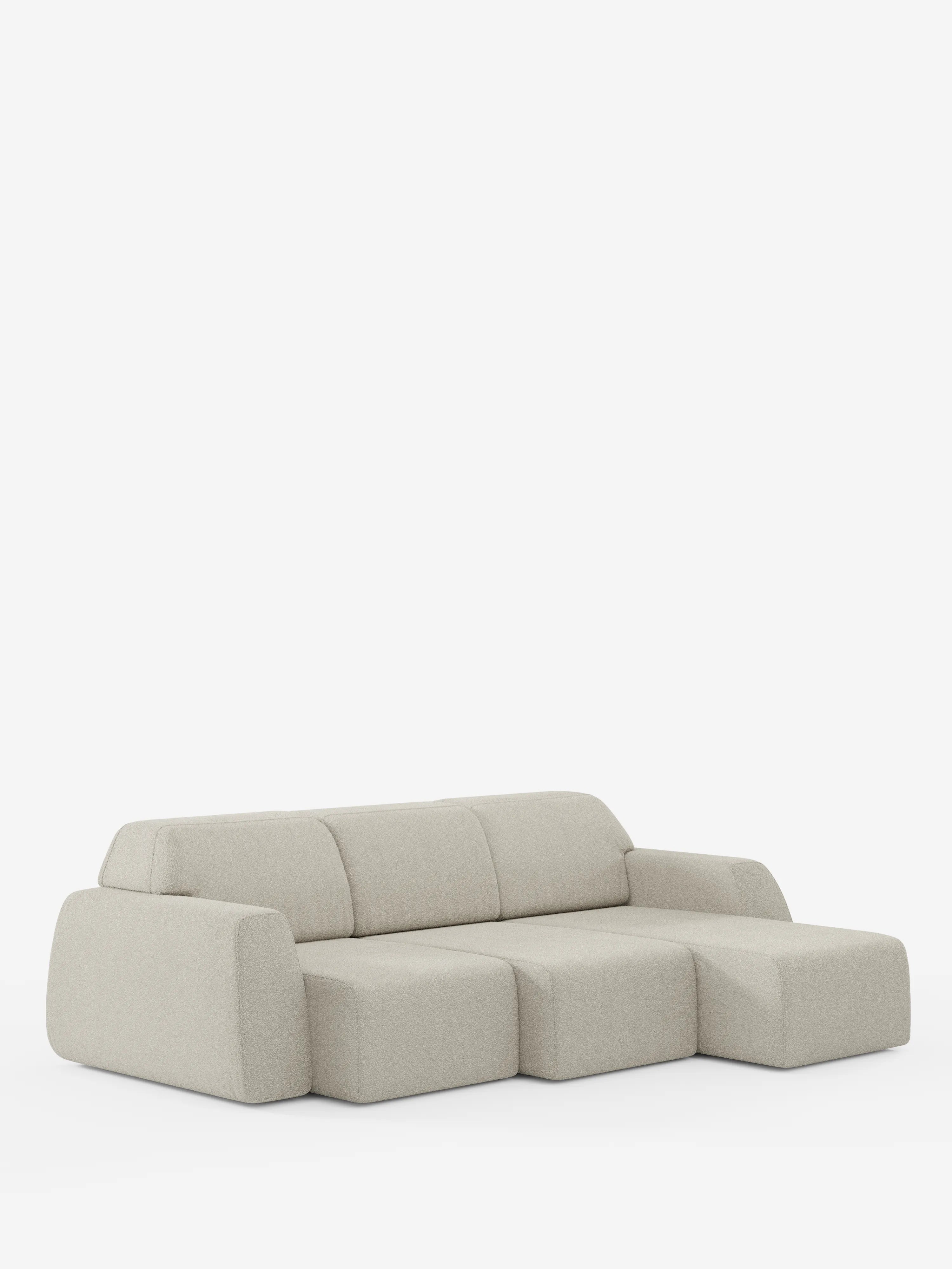 Il divano angolare Orbit con penisola reversibile e tutte le sedute allungabili in tessuto smacchiabile effetto cotone T33 di Divani.Store è un moderno divano modulare beige chiaro a tre posti, caratterizzato da ampi braccioli e da una sezione chaise longue sulla destra. Questo divano di alta gamma vanta bordi morbidi e arrotondati e un profilo basso, che risalta magnificamente su uno sfondo bianco a tinta unita.