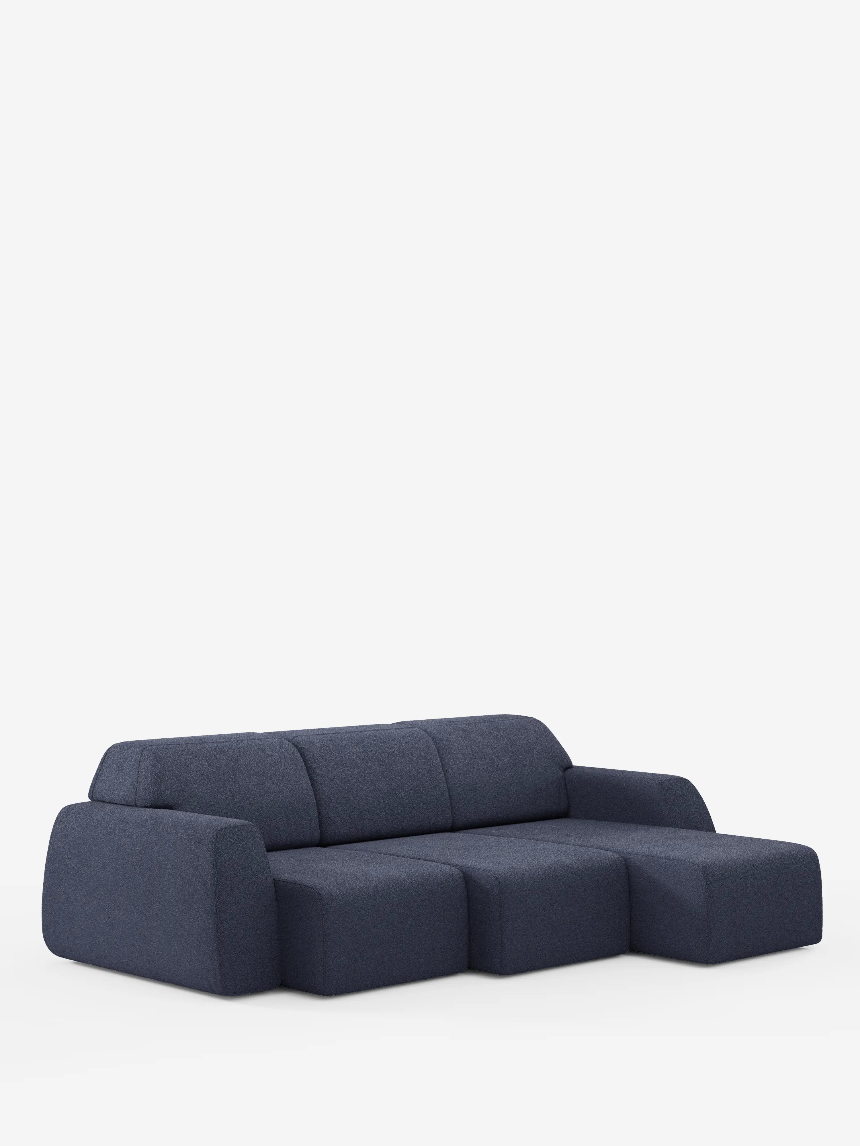 Un divano angolare Orbit contemporaneo in blu scuro di Divani.Store, caratterizzato da una chaise longue reversibile (penisola) e da tre cuscini di seduta allungati in tessuto T33 antimacchia effetto cotone. Con i suoi bordi arrotondati, lo schienale basso e il design moderno, questo divano di alta gamma offre sia un comfort eccezionale che uno stile sofisticato, messo in risalto da uno sfondo bianco a tinta unita.