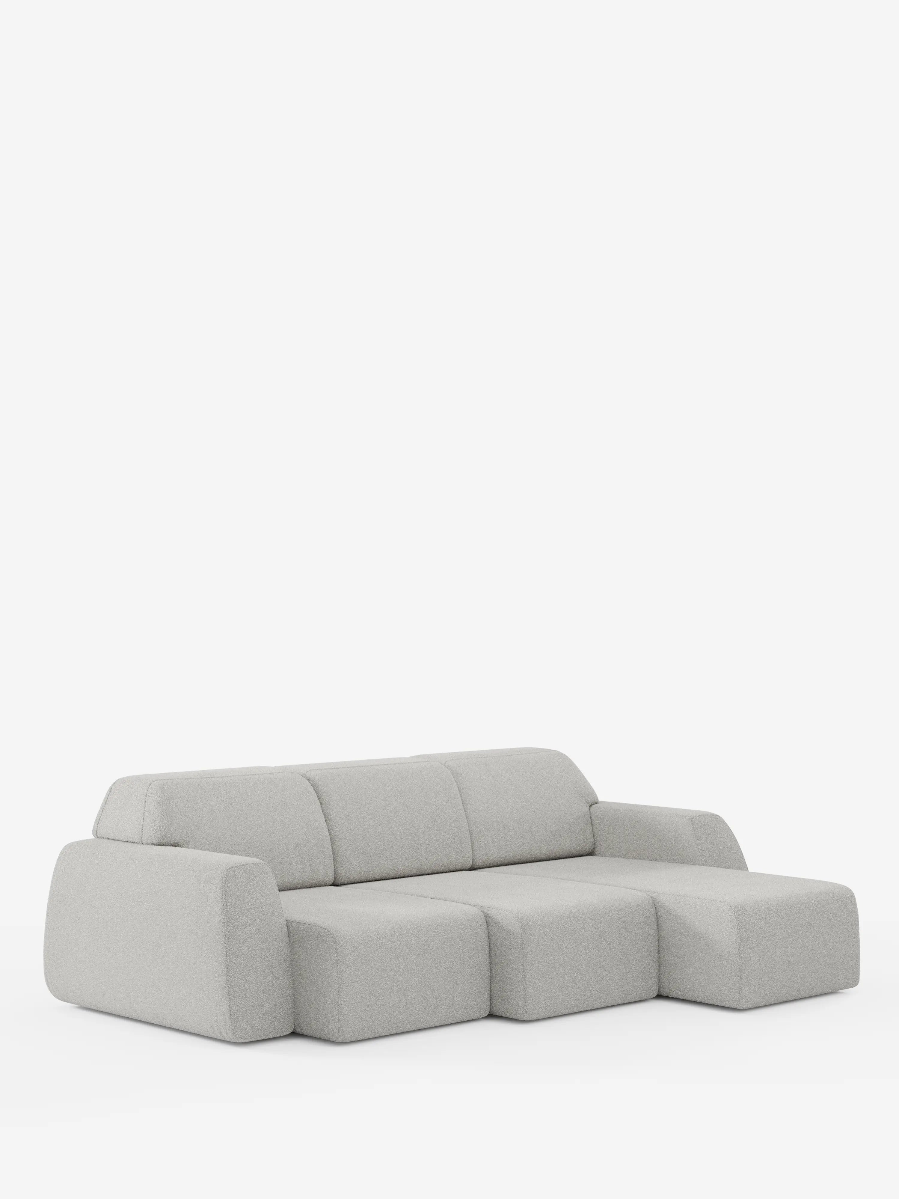 Il divano angolare Orbit di Divani.Store è un divano componibile minimalista e moderno, di colore grigio chiaro, che spicca su uno sfondo bianco a tinta unita. Questo divano modulare presenta forme morbide e geometriche, con braccioli e schienale bassi e arrotondati, ed è dotato di una chaise longue reversibile e di sedute estensibili rivestite in tessuto T33 effetto cotone antimacchia. Non sono visibili altri elementi decorativi o mobili.