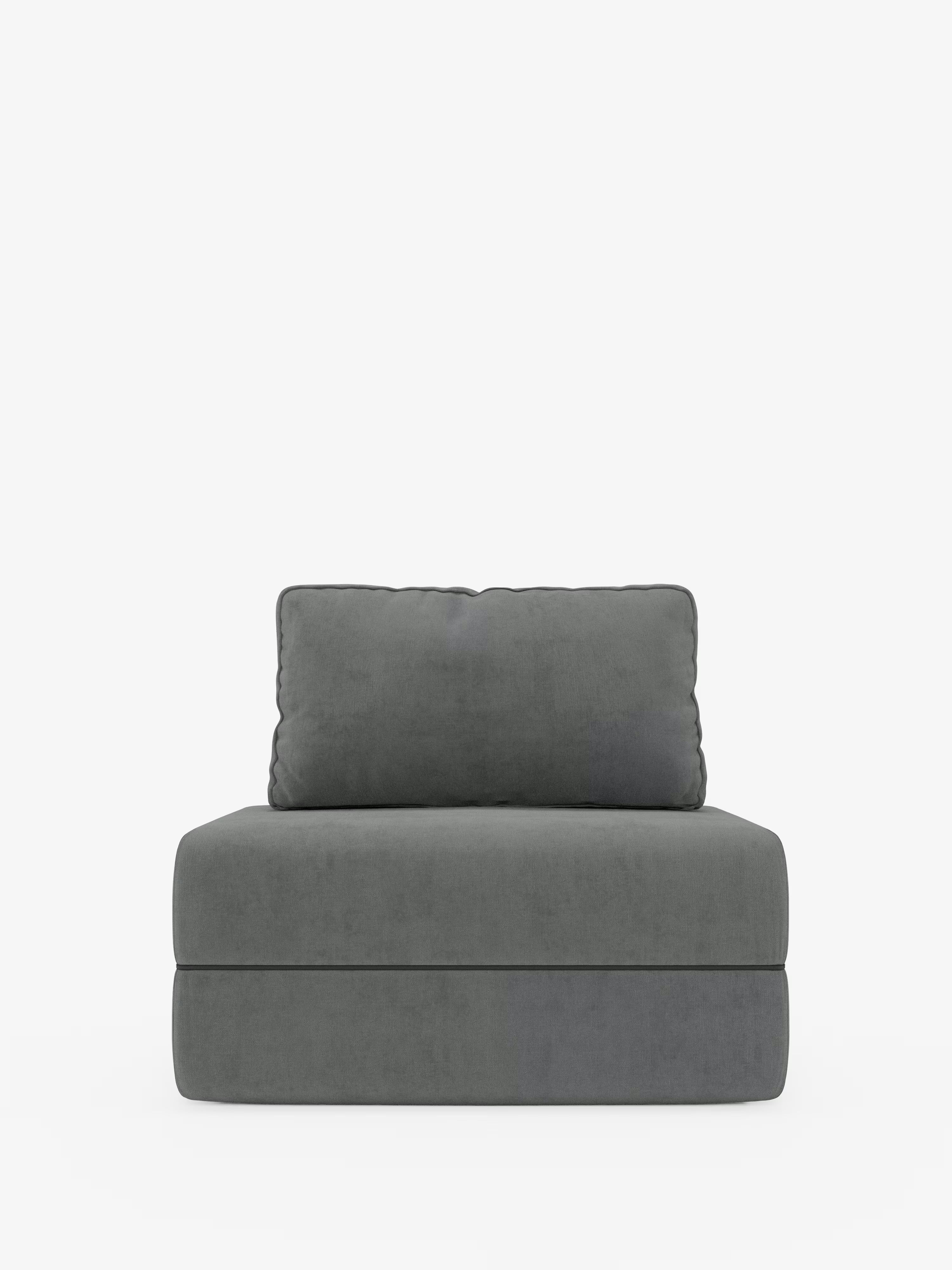 Una poltrona contemporanea senza braccioli, la Rift poltrona letto di Divani.Store, è raffigurata al centro di uno sfondo bianco a tinta unita. Rivestita in tessuto grigio scuro antimacchia (T31), presenta una seduta con materasso in memory foam dello spessore di 24 cm e uno schienale mobile rettangolare abbinato. Il design pulito e minimalista la rende una soluzione salvaspazio ideale per qualsiasi zona giorno moderna.