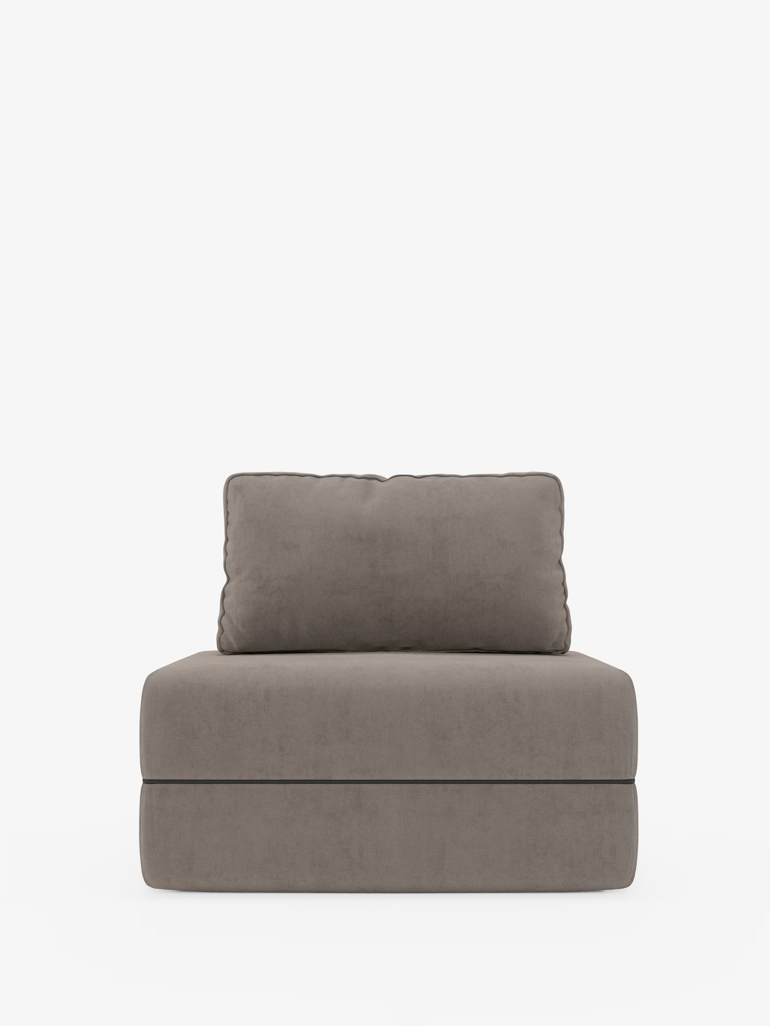 Una poltrona contemporanea senza braccioli di Divani.Store, la Rift poltrona letto presenta un morbido cuscino di seduta rettangolare e un cuscino dello schienale abbinato, entrambi rivestiti in morbido tessuto T31 grigio talpa resistente alle macchie. Caratterizzata da linee pulite e da una base minimalista senza giunture, vanta uno schienale regolabile e include un materasso in memory foam alto 24 cm, qui raffigurato su uno sfondo bianco.