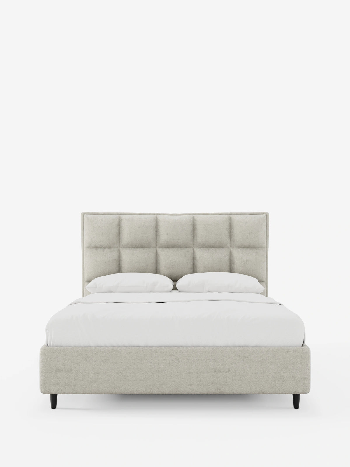 Un letto imbottito AURO con contenitore e testiera alta capitonné in ciniglia Oeko-Tex®, caratterizzato da una testiera beige chiaro con trapuntatura a quadrati, struttura abbinata su gambe affusolate scure e due cuscini bianchi sulla biancheria da letto.