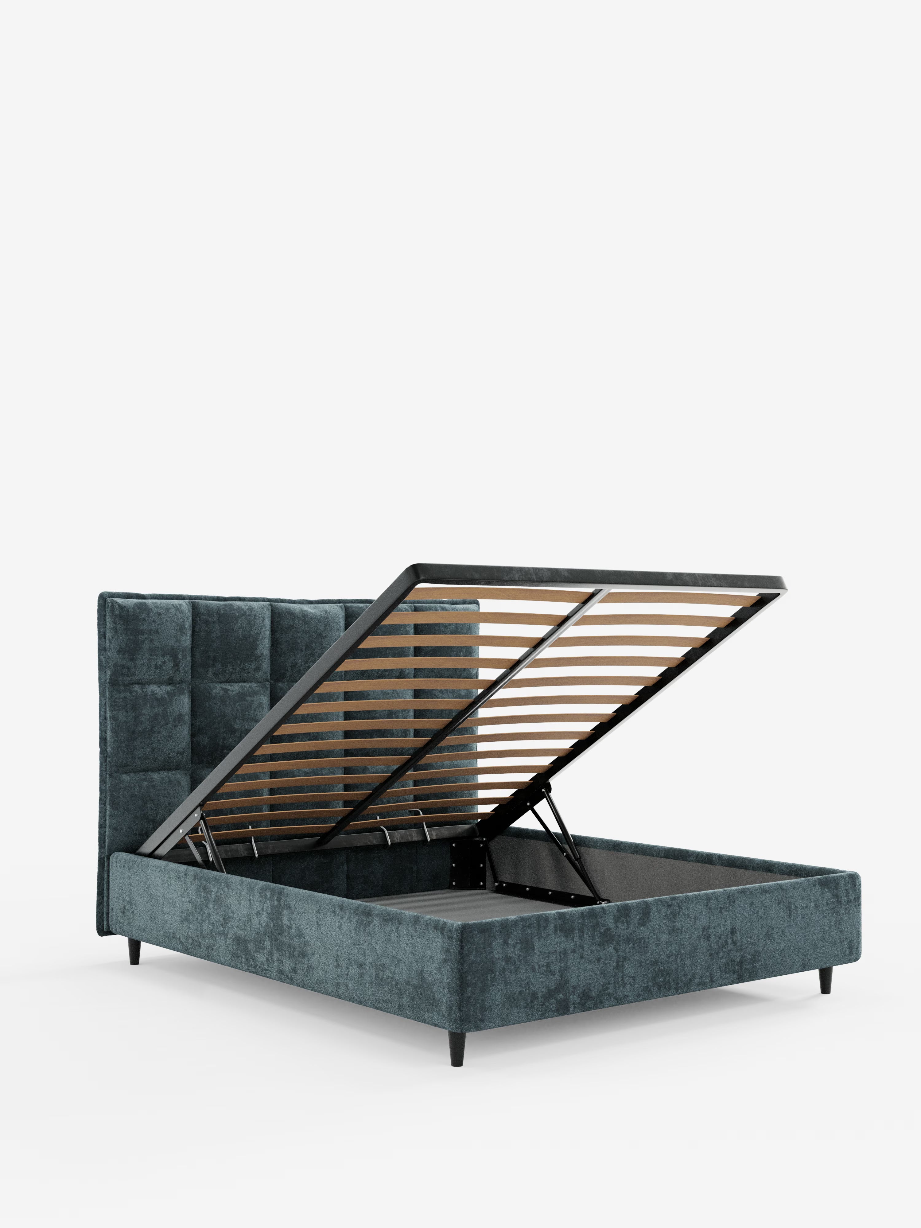Il letto imbottito AURO con contenitore e testiera alta capitonné in ciniglia Oeko-Tex® di Letti.store è un moderno letto imbottito con contenitore, di colore grigio scuro, caratterizzato da un'alta testiera capitonné. La base del materasso si solleva facilmente grazie a molle a gas, rivelando un ampio spazio di stivaggio sotto il letto, ed è sostenuta da eleganti gambe in metallo. Questo design personalizzabile esalta l’eleganza contemporanea ed è fotografato su uno sfondo bianco a tinta unita.