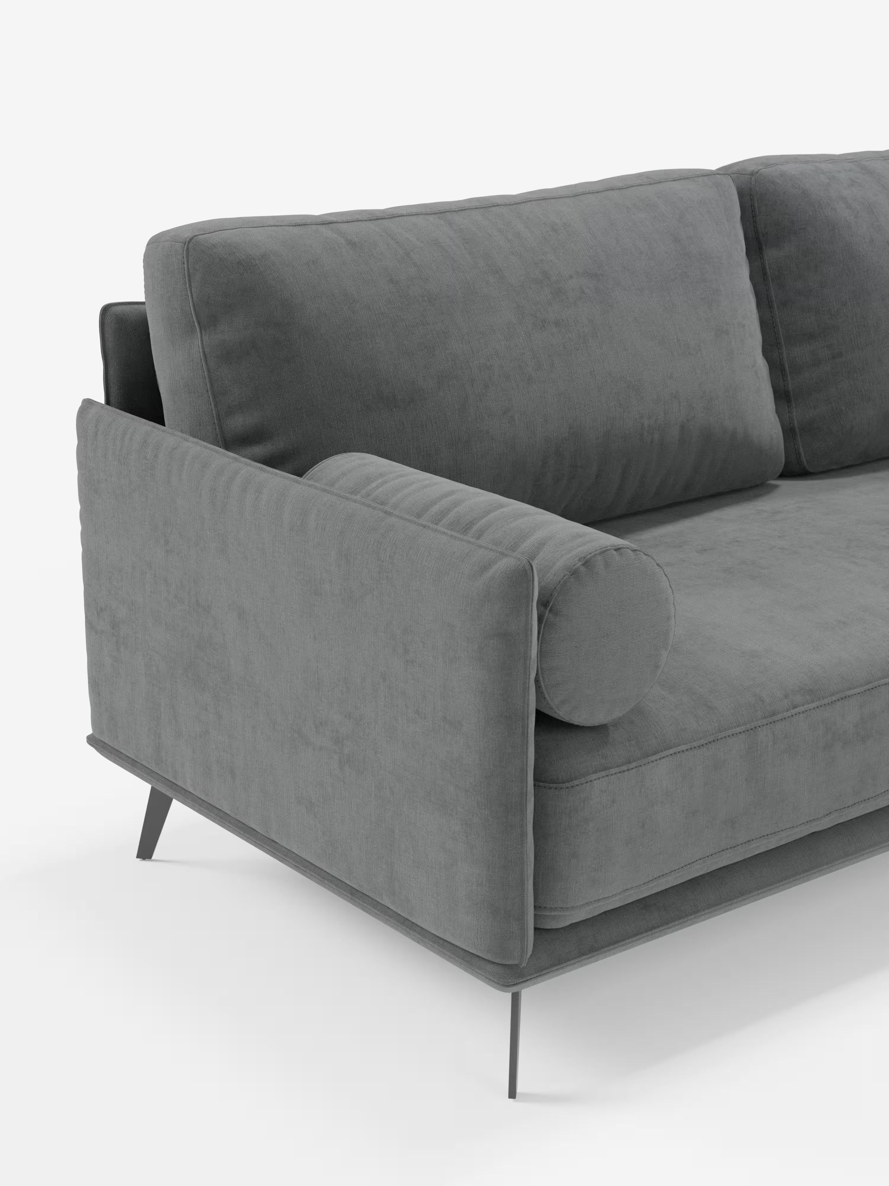 Il divano angolare contemporaneo Basalto Divano moderno con penisola di Divani.Store è presentato con morbidi e soffici cuscini in piuma rivestiti in tessuto T31 resistente alle macchie, un cuscino cilindrico appoggiato sul bracciolo e sottili gambe in metallo. Su uno sfondo bianco a tinta unita è visibile solo un angolo di questo divano italiano realizzato con maestria.