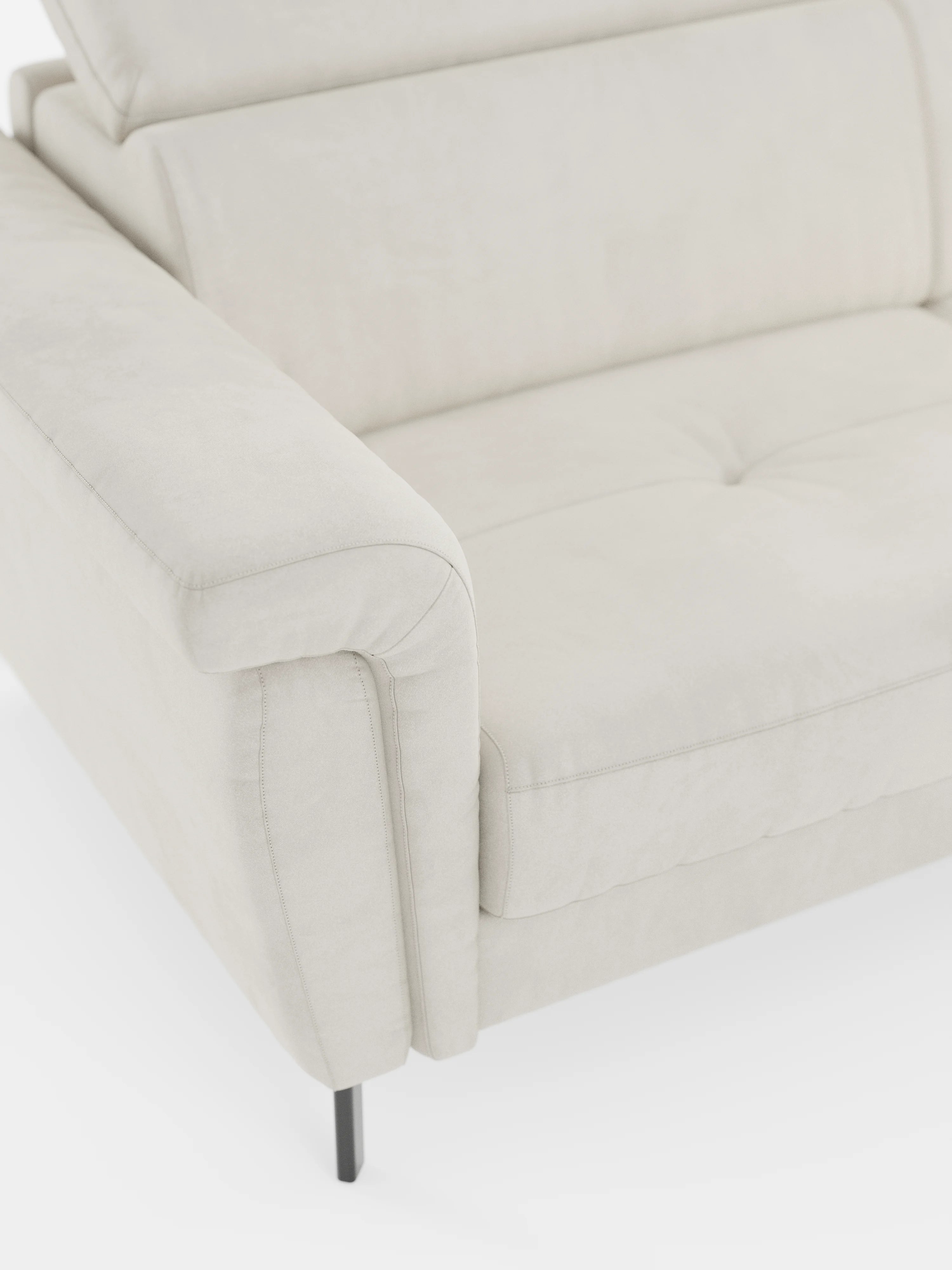 Primo piano del divano letto di design Capri con piedini alti di Divani.Store, rivestito in raffinato tessuto T30 effetto velluto, resistente alle macchie. Caratterizzato da un bracciolo imbottito, un cuscino di seduta trapuntato, gambe alte in metallo nero e poggiatesta regolabili, questo moderno divano letto è esposto su uno sfondo bianco per mettere in risalto la morbida trama del tessuto effetto velluto e il suo design pulito e contemporaneo.