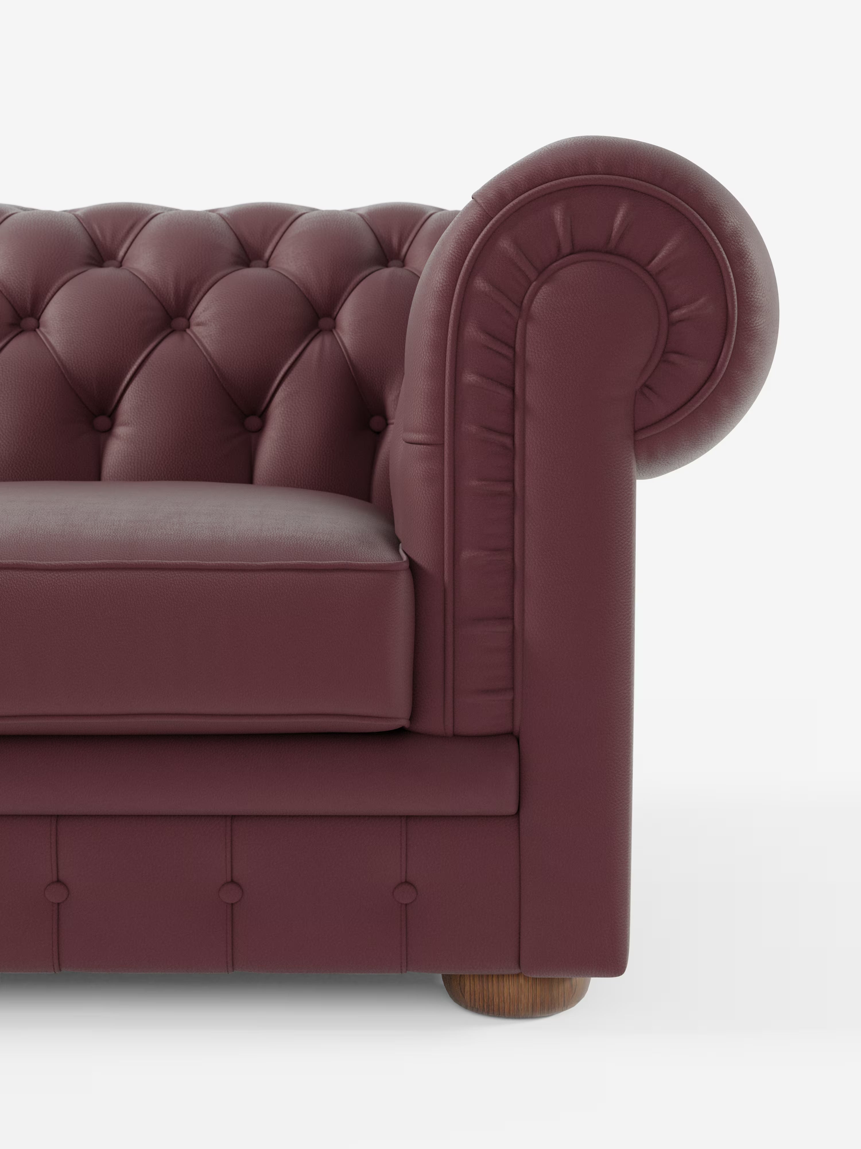 Primo piano del divano Chester 4 Posti 3 sedute in vera pelle – Chesterfield capitonné artigianale di Divani.Modello in color bordeaux, caratterizzato da rivestimento in vera pelle capitonné, seduta imbottita e bracciolo destro arrotondato con gamba cilindrica in legno alla base, il tutto su uno sfondo bianco a tinta unita.