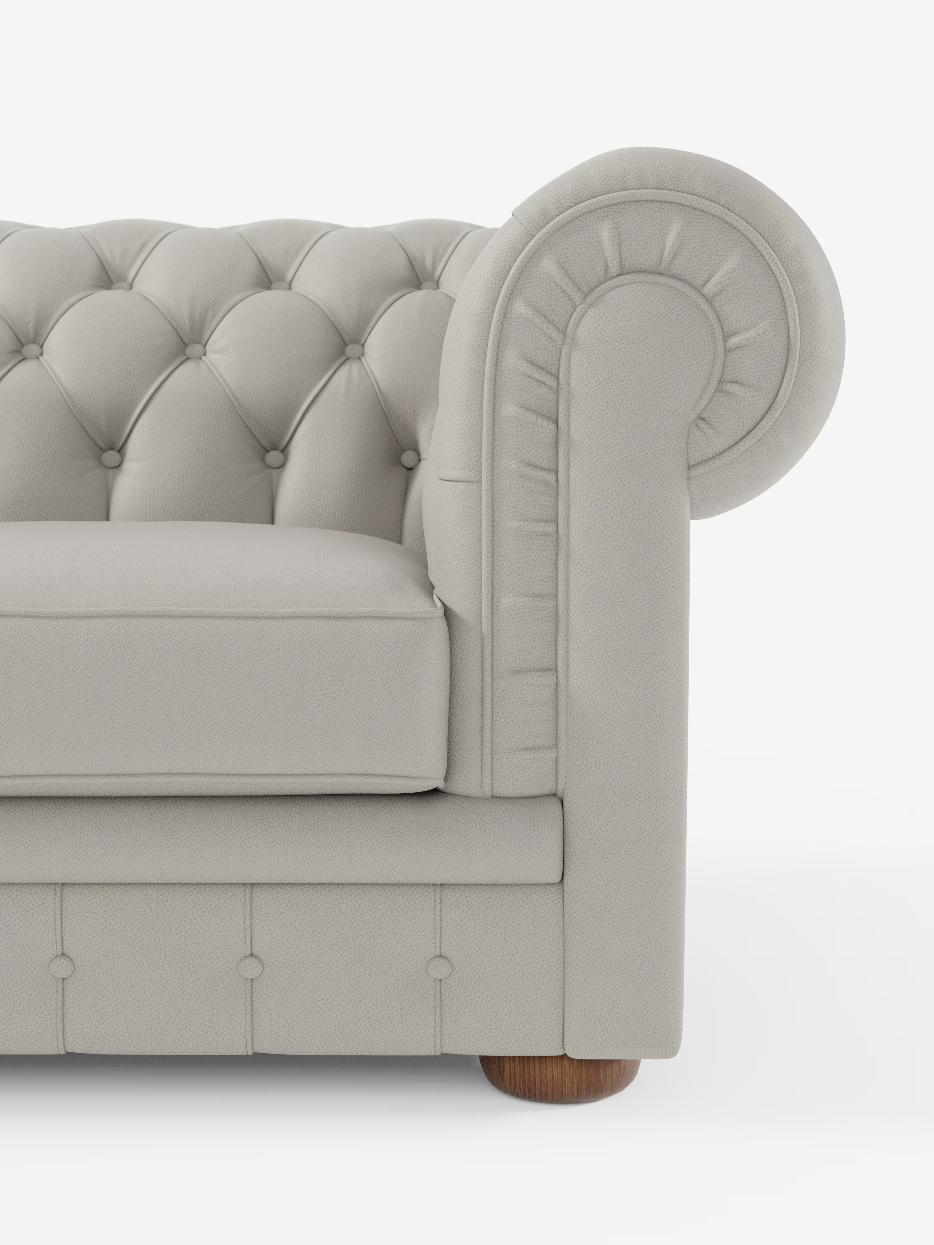 Primo piano del bracciolo destro del divano Chester 4 Posti 3 sedute in vera pelle – Chesterfield Capitonné Artigianale di Divani.Store, caratterizzato da bracciolo arrotondato, schienale e parte anteriore trapuntati con bottoni, piedini rotondi in legno e cuscini morbidi. Questo elegante divano Chesterfield realizzato a mano in Italia è ripreso su uno sfondo bianco a tinta unita.