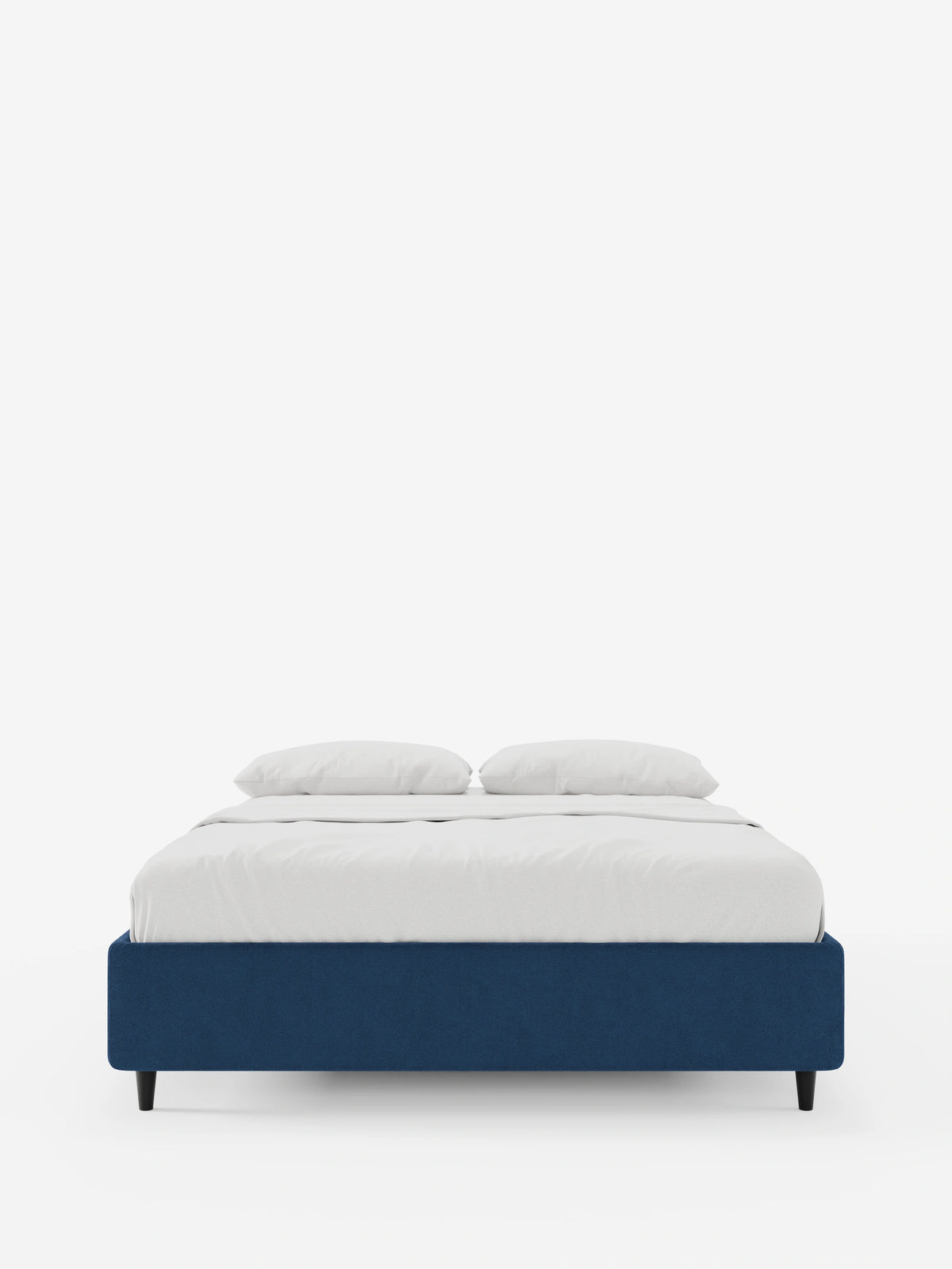 Un letto sommier imbottito ERON con contenitore in tessuto impermeabile certificato Oeko-Tex, con struttura blu navy e quattro gambe corte nere, rivestito con lenzuola bianche immacolate e due morbidi cuscini su uno sfondo bianco a tinta unita.