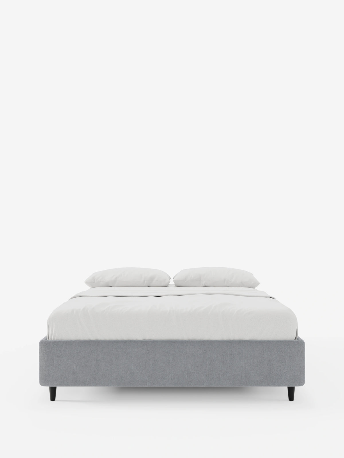 Il letto sommier imbottito ERON con contenitore in tessuto impermeabile certificato Oeko-Tex è un letto moderno, dal profilo basso, di colore grigio, con gambe corte scure, rivestito con biancheria da letto di un bianco brillante e due cuscini su uno sfondo bianco.