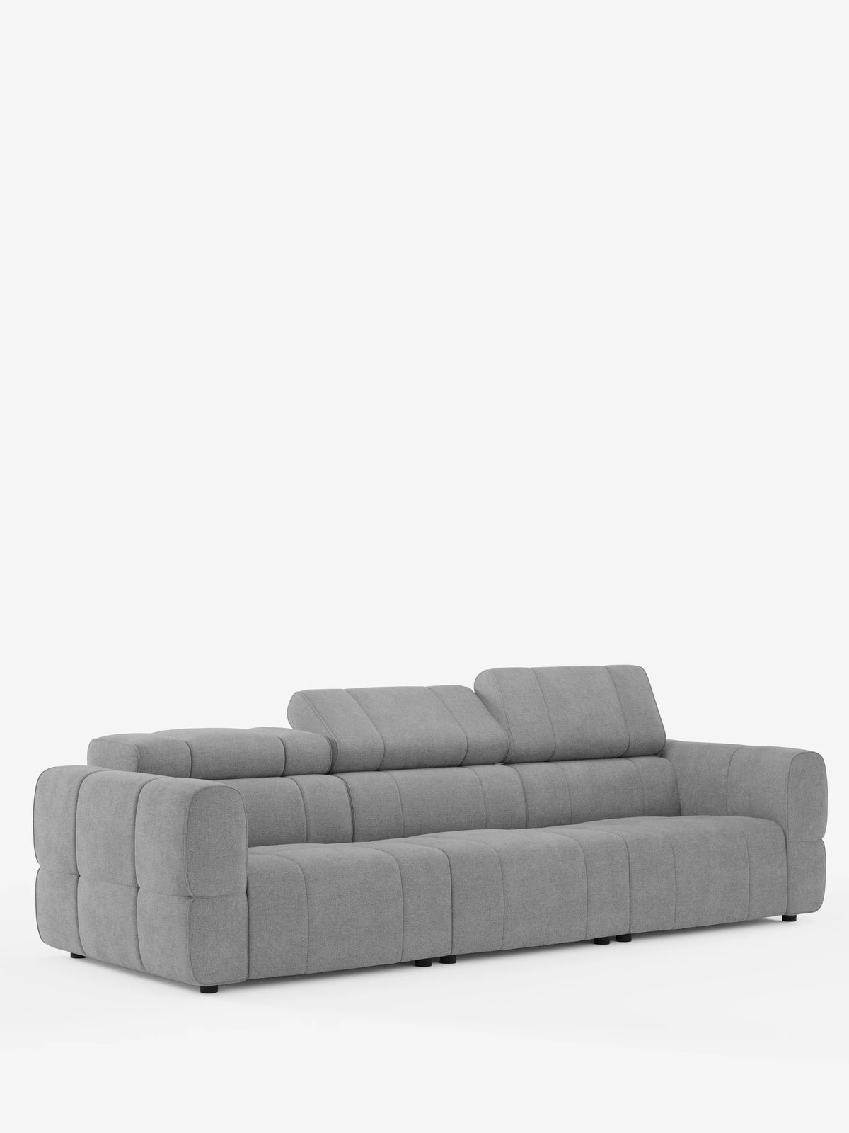 Un divano modulare Giotto grigio chiaro a 4 posti con poggiatesta reclinabili e funzione relax elettrica opzionale, rivestito in tessuto smacchiabile T23, caratterizzato da cuciture verticali, braccioli bassi e poggiatesta regolabili, su uno sfondo bianco a tinta unita.