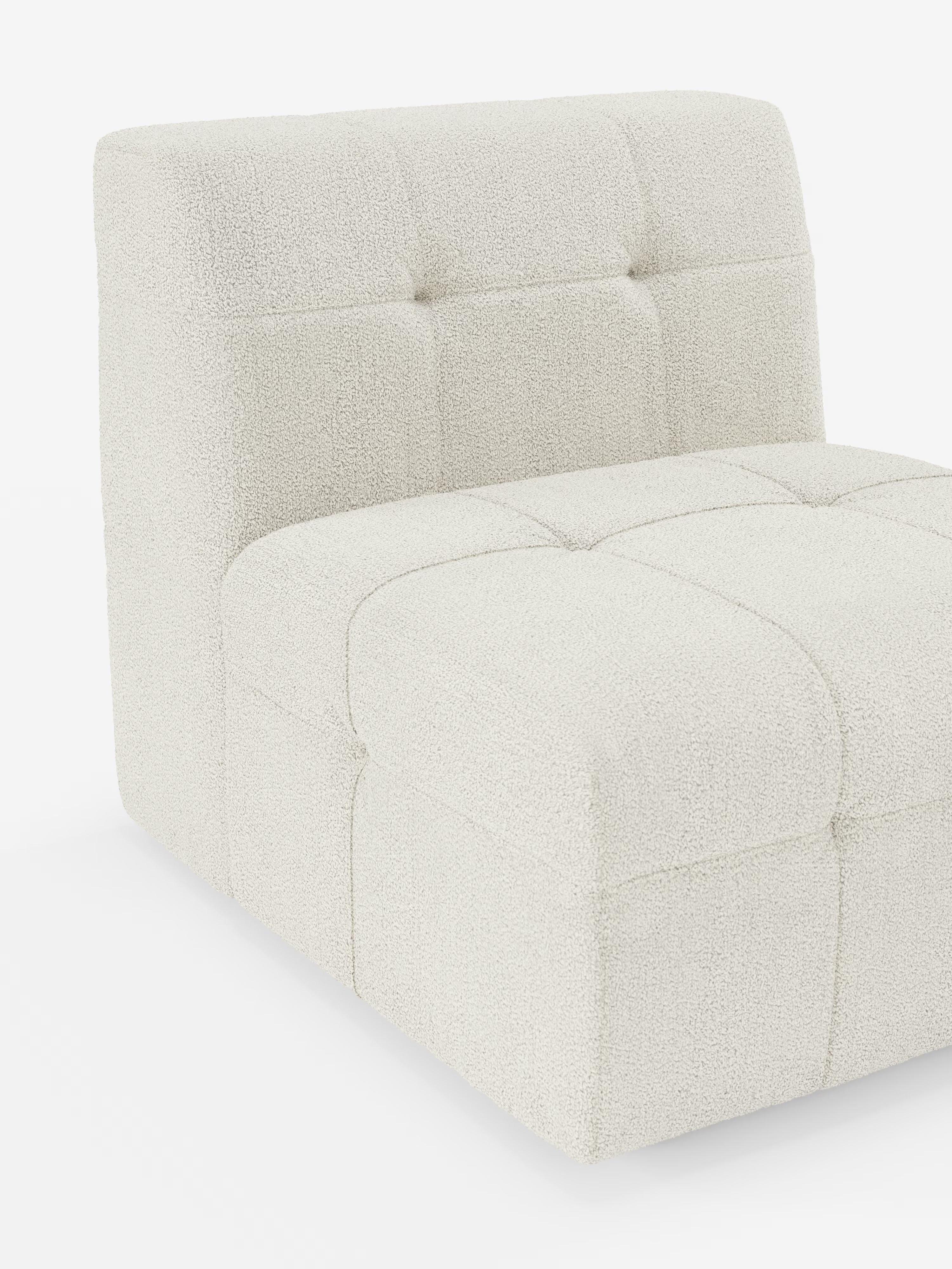 Vi presentiamo la poltrona Mosaic modulo da 77 cm in bouclé di Divani.Store: una poltrona contemporanea senza braccioli, rivestita in bouclé T21 color bianco sporco e resistente alle macchie. Il design capitonné mette in risalto le sezioni quadrate trapuntate sulla seduta e sullo schienale, creando un effetto morbido e materico che incarna lo stile moderno. Perfettamente valorizzata su uno sfondo bianco, questa poltrona è l’espressione ideale dell’elegante maestria artigianale.