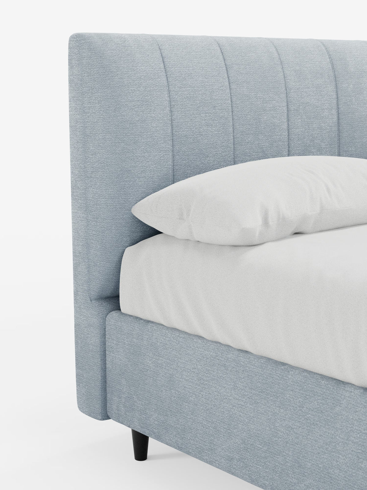 In azzurro è raffigurato un primo piano del letto imbottito ONYX con contenitore e testiera verticale in tessuto certificato Oeko-Tex® di Letti.store. Il letto presenta una trapuntatura a canali verticali sulla testiera imbottita, un cuscino e un lenzuolo bianchi e immacolati, nonché eleganti gambe affusolate di colore nero. Lo sfondo bianco a tinta unita mette in risalto il design pulito e contemporaneo di questo moderno letto imbottito.