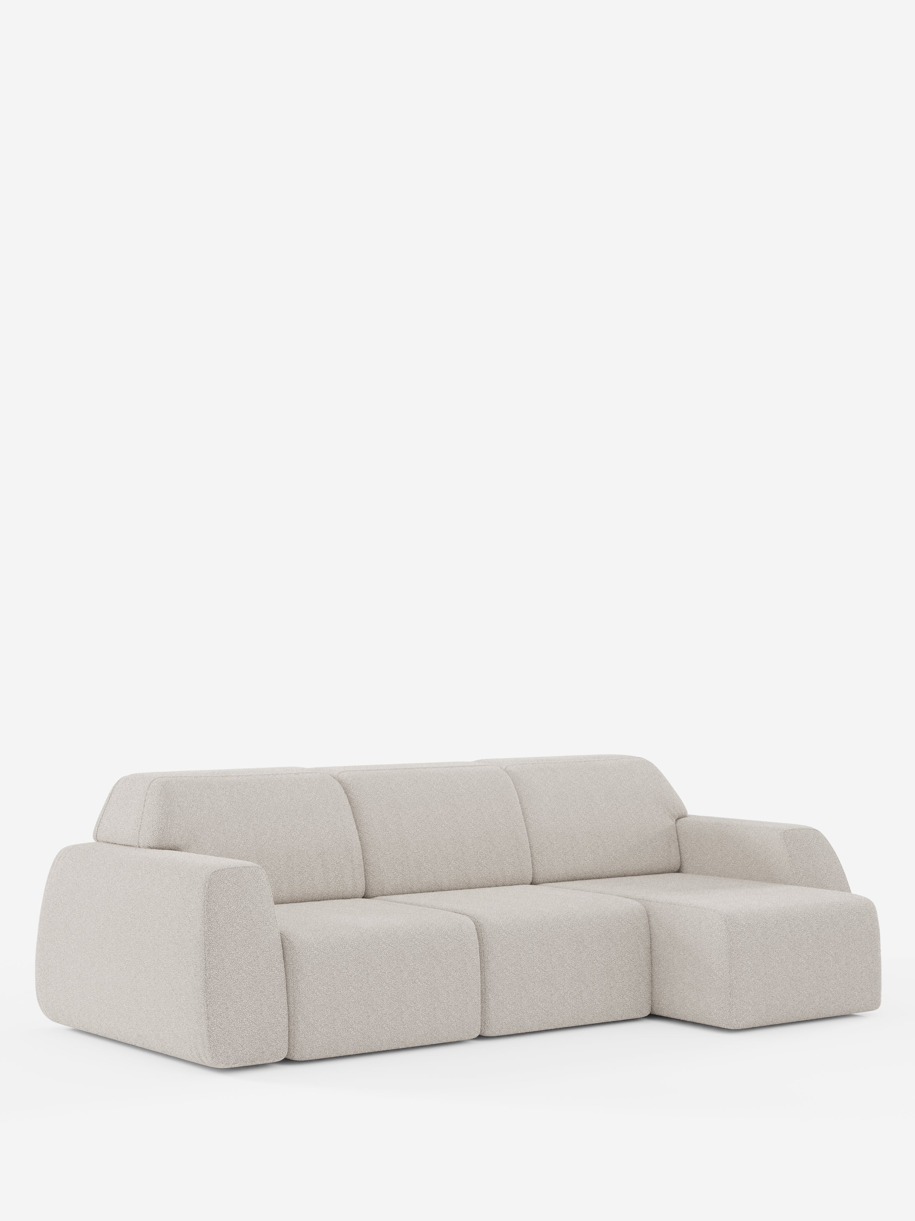 Orbit Divano angolare con penisola reversibile e tutte le sedute allungabili in tessuto smacchiabile effetto cotone T33 di Divani.Store è un divano modulare moderno, color beige chiaro, caratterizzato da linee morbide e arrotondate e da cuscini soffici. Questo divano a tre posti di alta gamma presenta una chaise longue sul lato destro (penisola reversibile), rifinito in stile minimalista senza gambe a vista né decorazioni, ed è fotografato su uno sfondo bianco a tinta unita.
