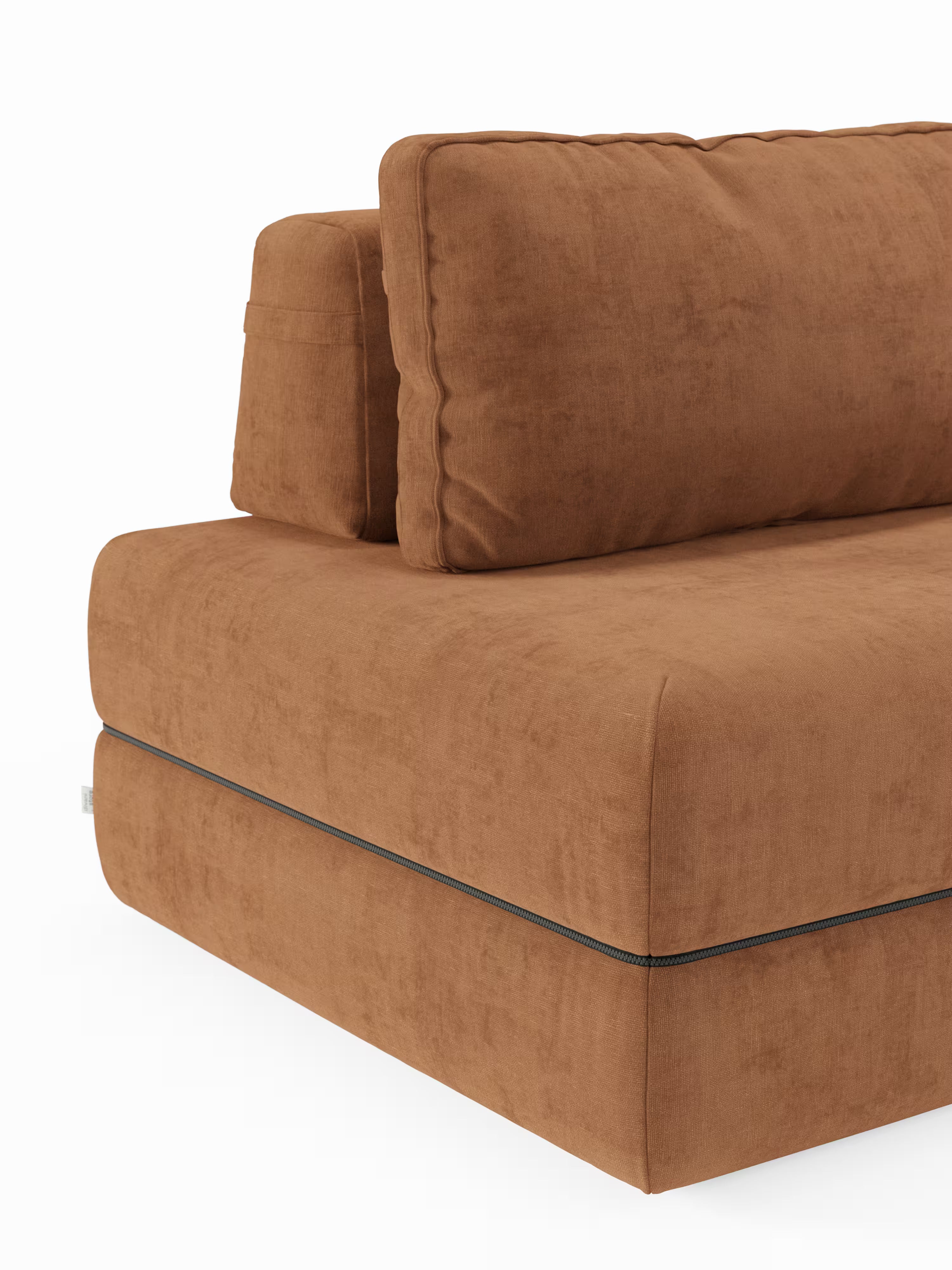 Primo piano del divano letto matrimoniale Rift a 2 e 3 posti di Divani.Store, caratterizzato da morbidi cuscini rettangolari rivestiti in tessuto scamosciato color ruggine. Il rivestimento morbido e leggermente testurizzato è impreziosito da una cerniera nera a vista che corre orizzontalmente lungo la base. Gli schienali mobili aggiungono versatilità e comfort, con un materasso in memory foam alto 22 cm nella versione T31 discretamente integrato nel design moderno. Lo sfondo è bianco.