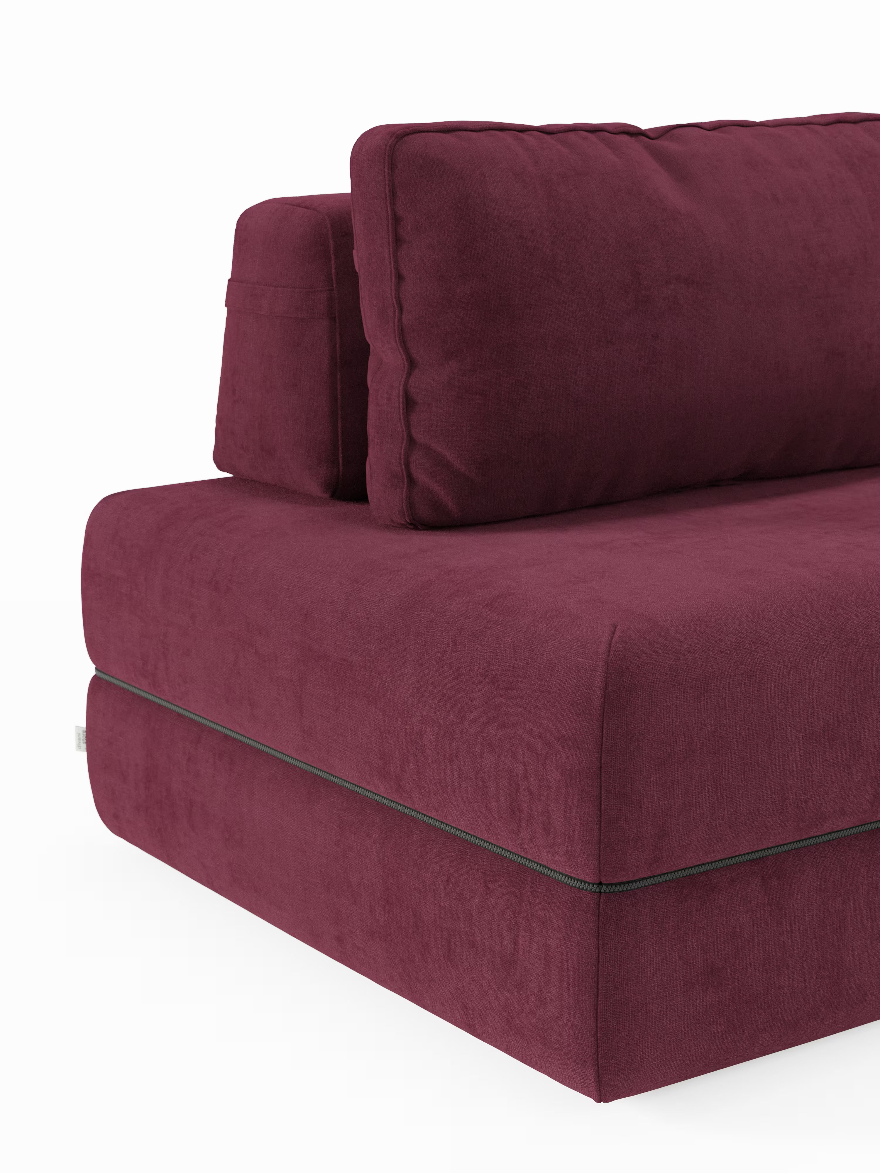 Un primo piano del divano letto matrimoniale Rift a 2 e 3 posti con schienali mobili di Divani.Store, che ne mette in risalto la moderna seduta squadrata, il cuscino dello schienale spesso, i dettagli delle cuciture a vista e le linee pulite e minimaliste. Il divano letto è rivestito in un ricco tessuto bordeaux e presenta un materasso in memory foam T31 alto 22 cm, che spicca sullo sfondo bianco.