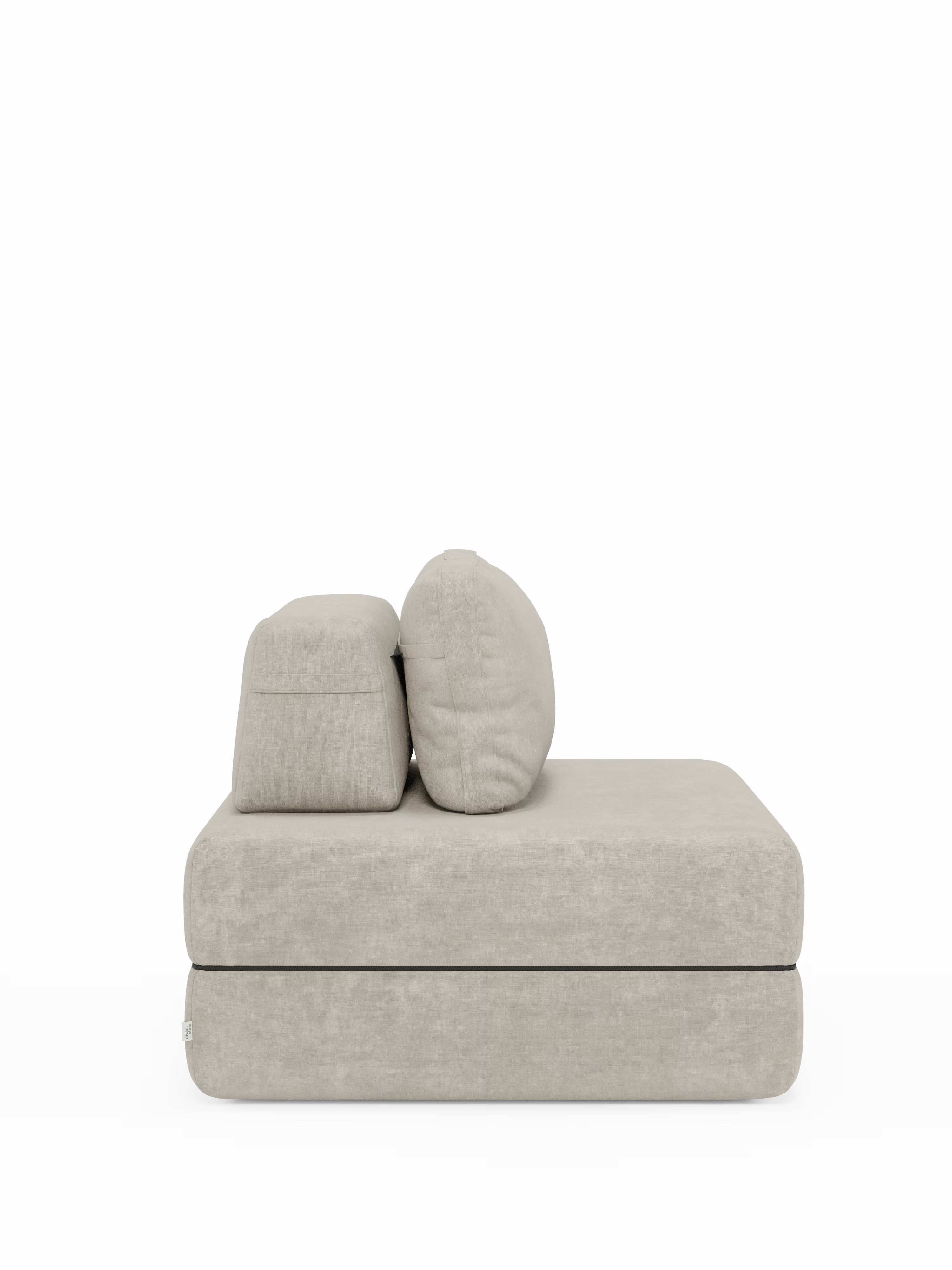 Una moderna poltrona letto Rift di Divani.Store, in beige chiaro, con un materasso in memory foam alto 24 cm e due cuscini dello schienale di generose dimensioni, è posizionata su uno sfondo bianco a tinta unita. La sua morbida seduta rettangolare, lo schienale regolabile e il rivestimento T31 facile da pulire ne sottolineano la versatilità e il comfort, rendendola una poltrona salvaspazio ideale per gli spazi abitativi contemporanei.