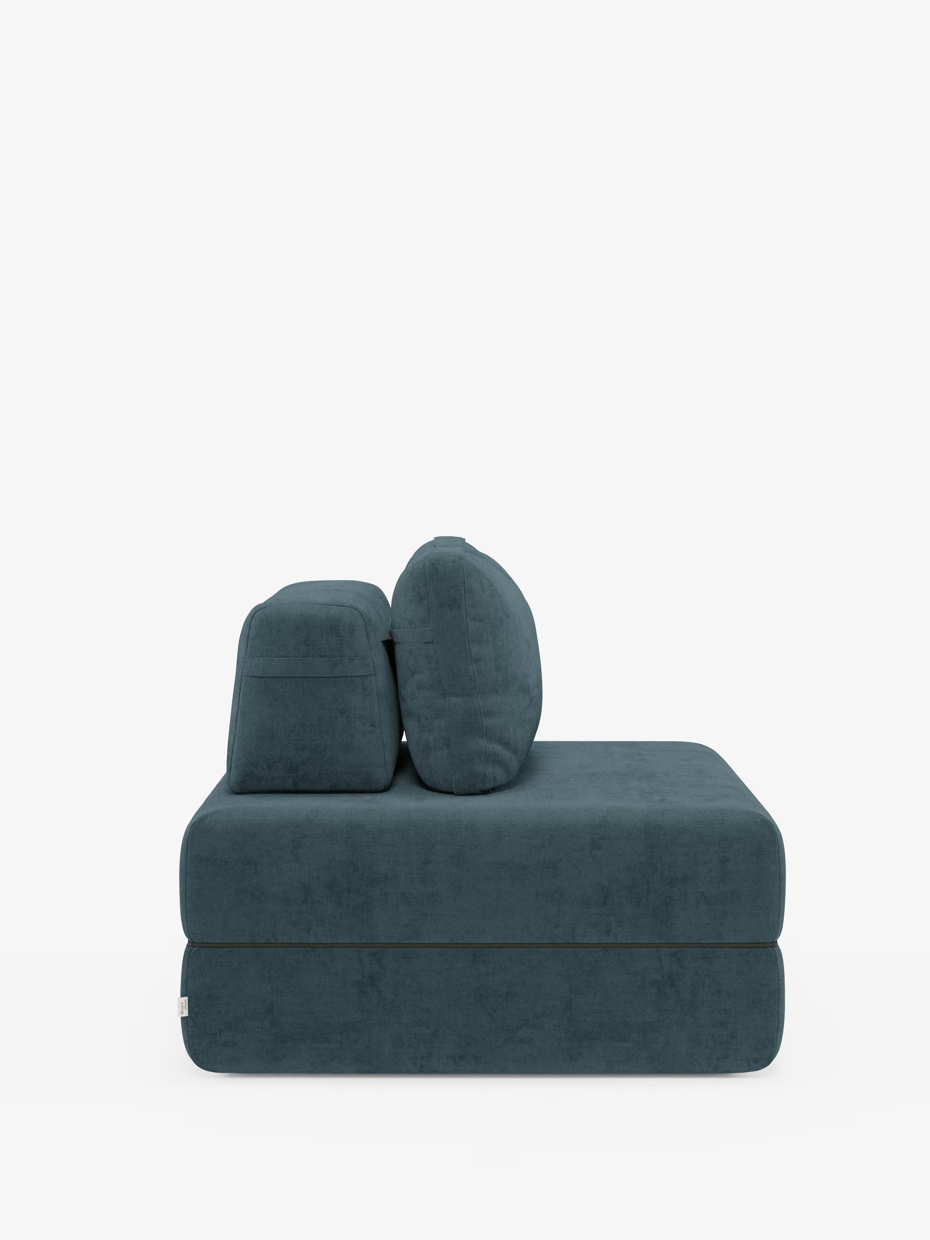 Una poltrona letto Rift contemporanea di Divani.Store, in una tonalità verde acqua intenso, è raffigurata di profilo, caratterizzata da cuscini di seduta spessi e morbidi e da due grandi cuscini quadrati per lo schienale. Rivestita in morbido tessuto T31 resistente alle macchie, vanta un materasso in memory foam alto 24 cm e uno schienale regolabile. Ricordando una poltrona minimalista senza braccioli, i suoi bordi puliti e arrotondati risaltano sullo sfondo bianco.