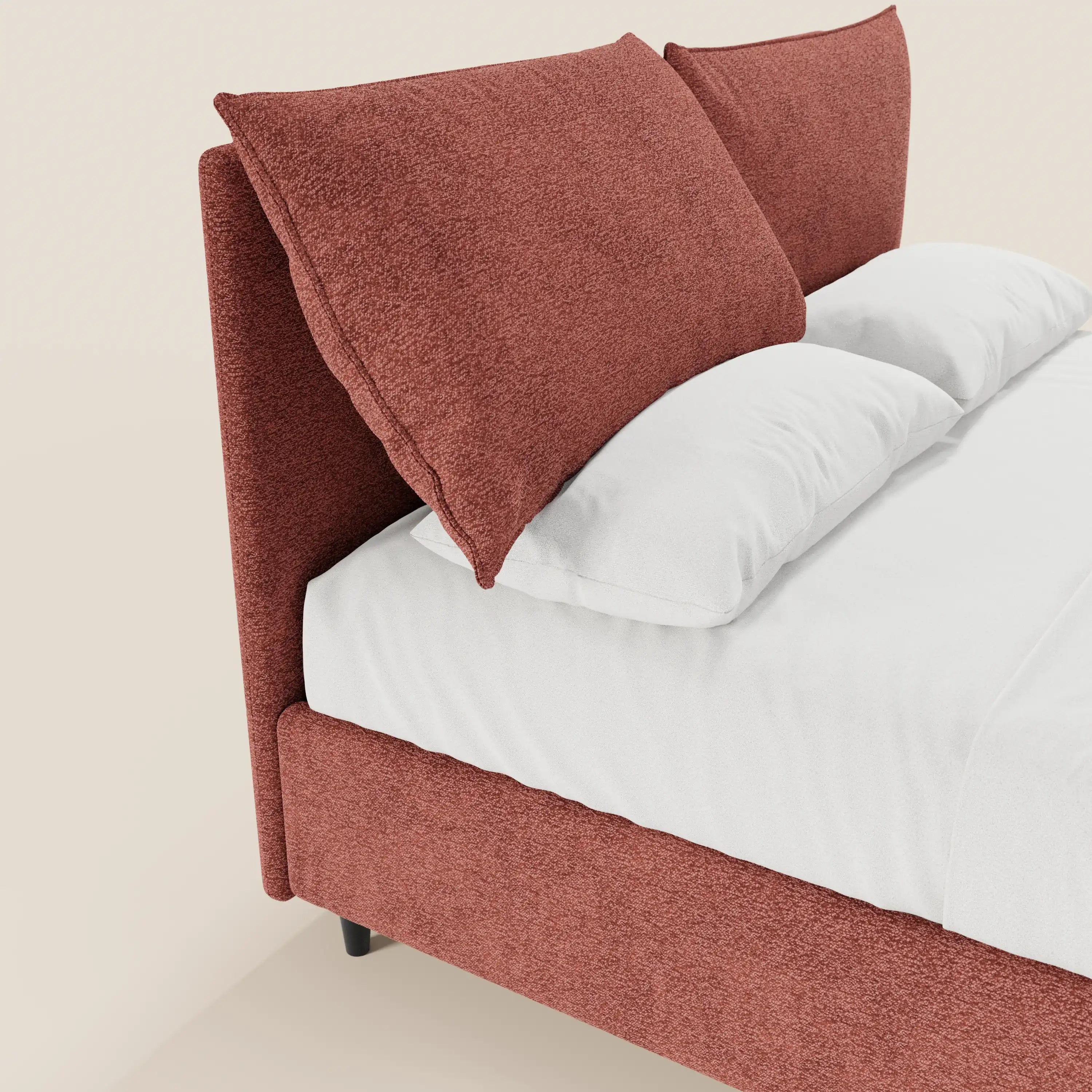 Un primo piano del letto imbottito con contenitore ZAYRON di Letti.store, caratterizzato da morbidi cuscini regolabili in tessuto certificato Oeko-Tex®, lenzuola bianchissime e un design moderno che risalta su uno sfondo beige chiaro.
