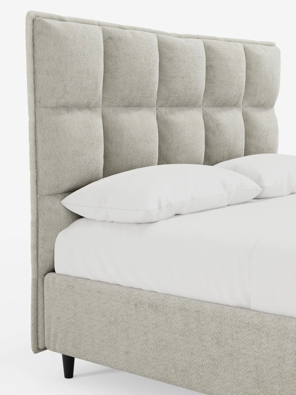 Letto imbottito AURO con contenitore e testiera capitonné alta in ciniglia Oeko-Tex®, caratterizzato da una testiera alta, di colore grigio chiaro, con motivo a quadrati capitonné e da morbidi tessuti bianchi su uno sfondo bianco a tinta unita.