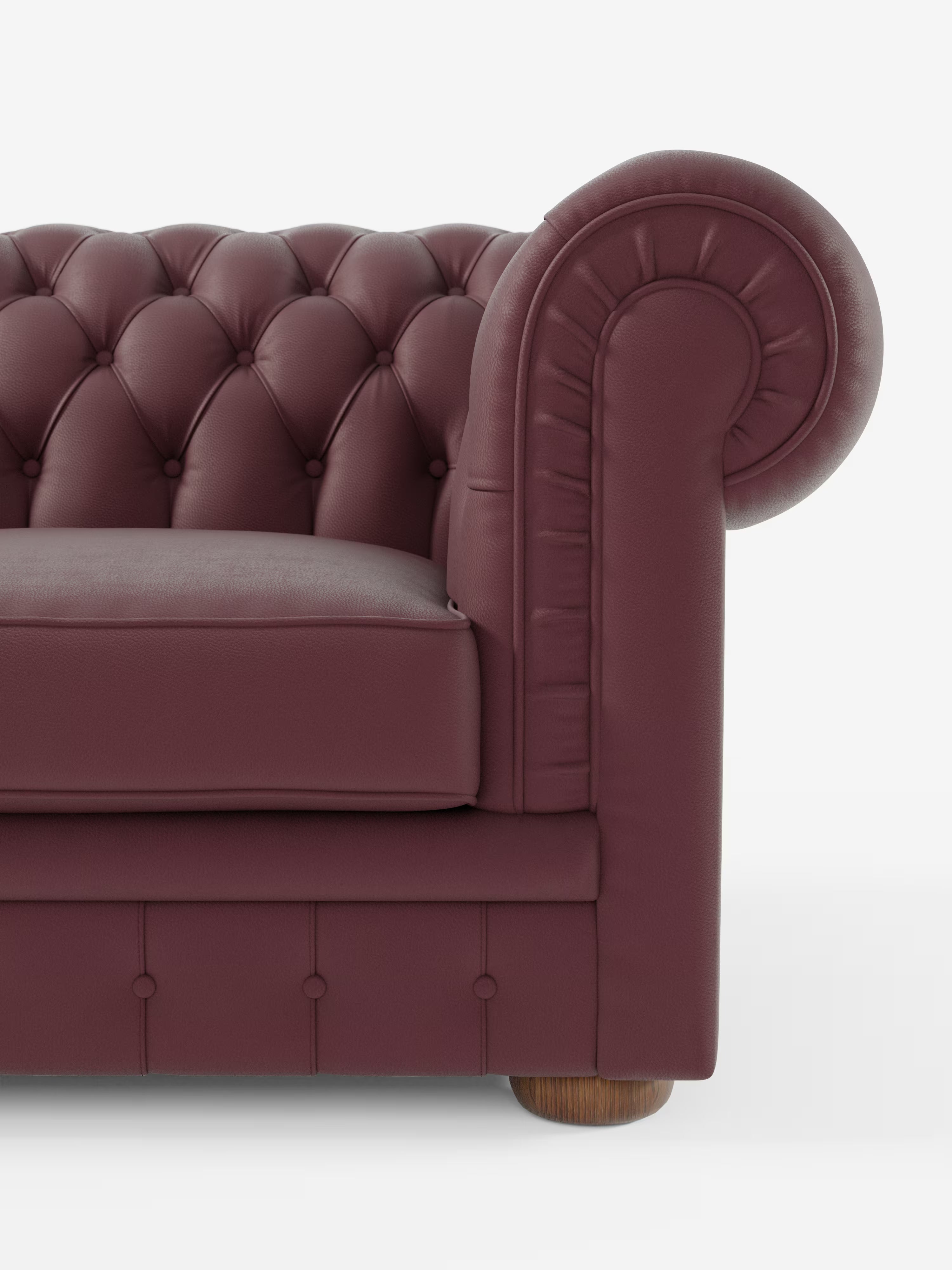 Un primo piano del Chester – Divano Chesterfield in vera pelle spessorata a 2 e 3 posti di Divani.Store mette in risalto la profonda trapuntatura a bottoni, i braccioli generosamente arrotondati e le gambe in legno che risaltano sullo sfondo bianco. Il morbido cuscino di seduta e il rivestimento in pelle liscia color bordeaux sottolineano i classici dettagli di design artigianale caratteristici di un divano artigianale Made in Italy.