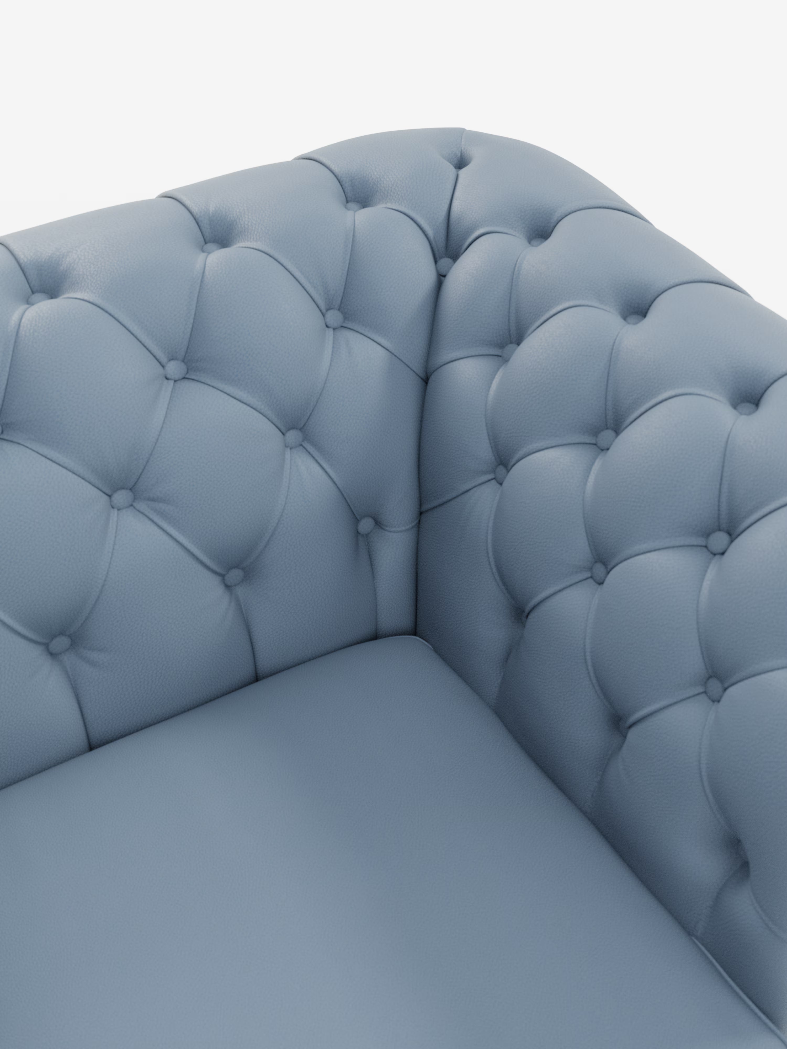 Primo piano di un divano ad angolo in pelle blu trapuntata, con motivo a rombi profondamente bottonato sullo schienale e sui braccioli, che mette in risalto la seduta morbida e imbottita e la texture soffice. Il Chester 4 Posti 3 sedute in Vera Pelle – Chesterfield Capitonné Artigianale di Divani.Store è realizzato in vera pelle; lo sfondo bianco a tinta unita mette in risalto gli squisiti dettagli del rivestimento Made in Italy.