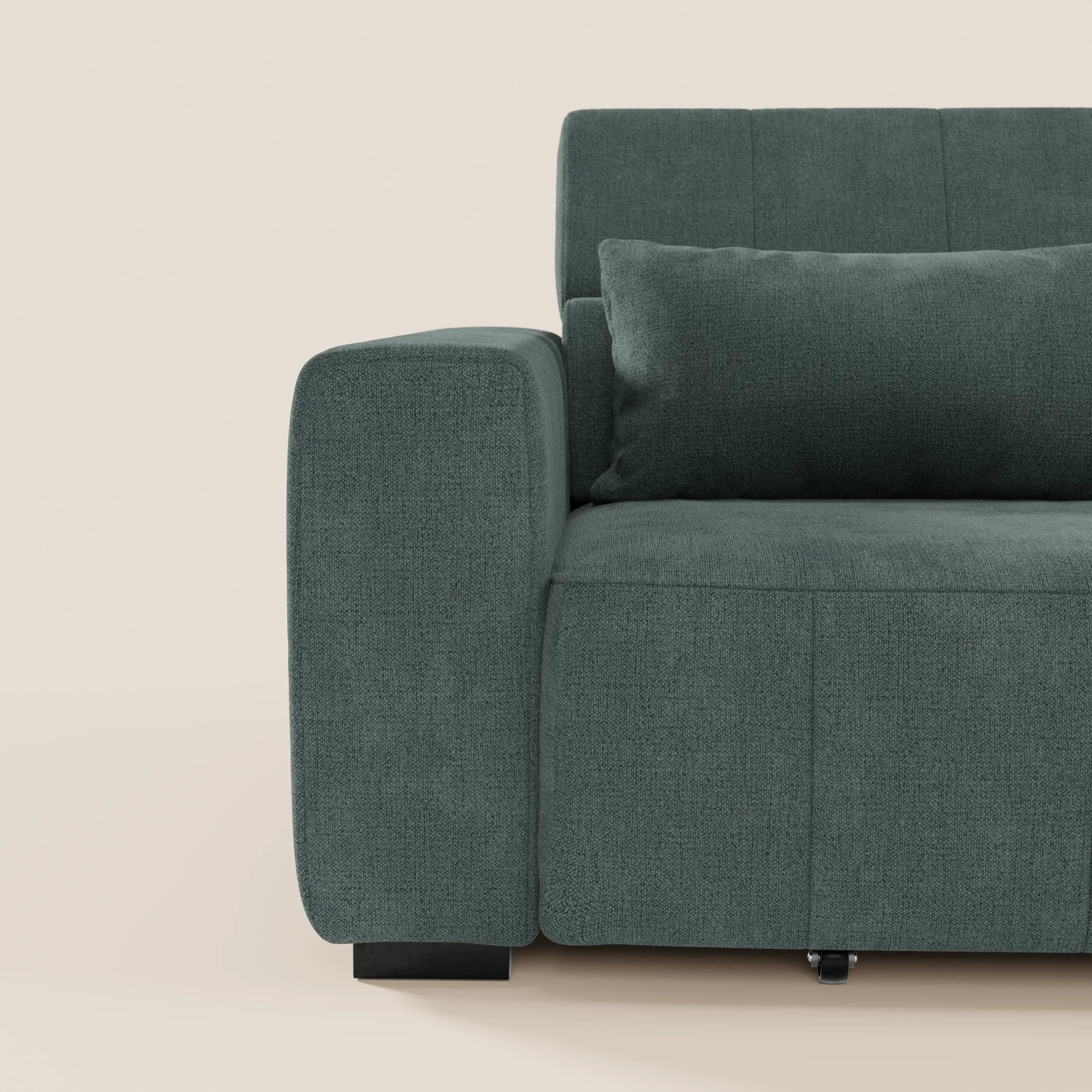 Primo piano della parte sinistra del divano Doric 3 posti di Divani.Store, rivestito in tessuto antimacchia T23 verde scuro, con ampio bracciolo, cuscini di seduta rigidi, cuscino rettangolare e reclinazione elettrica su sfondo beige chiaro.