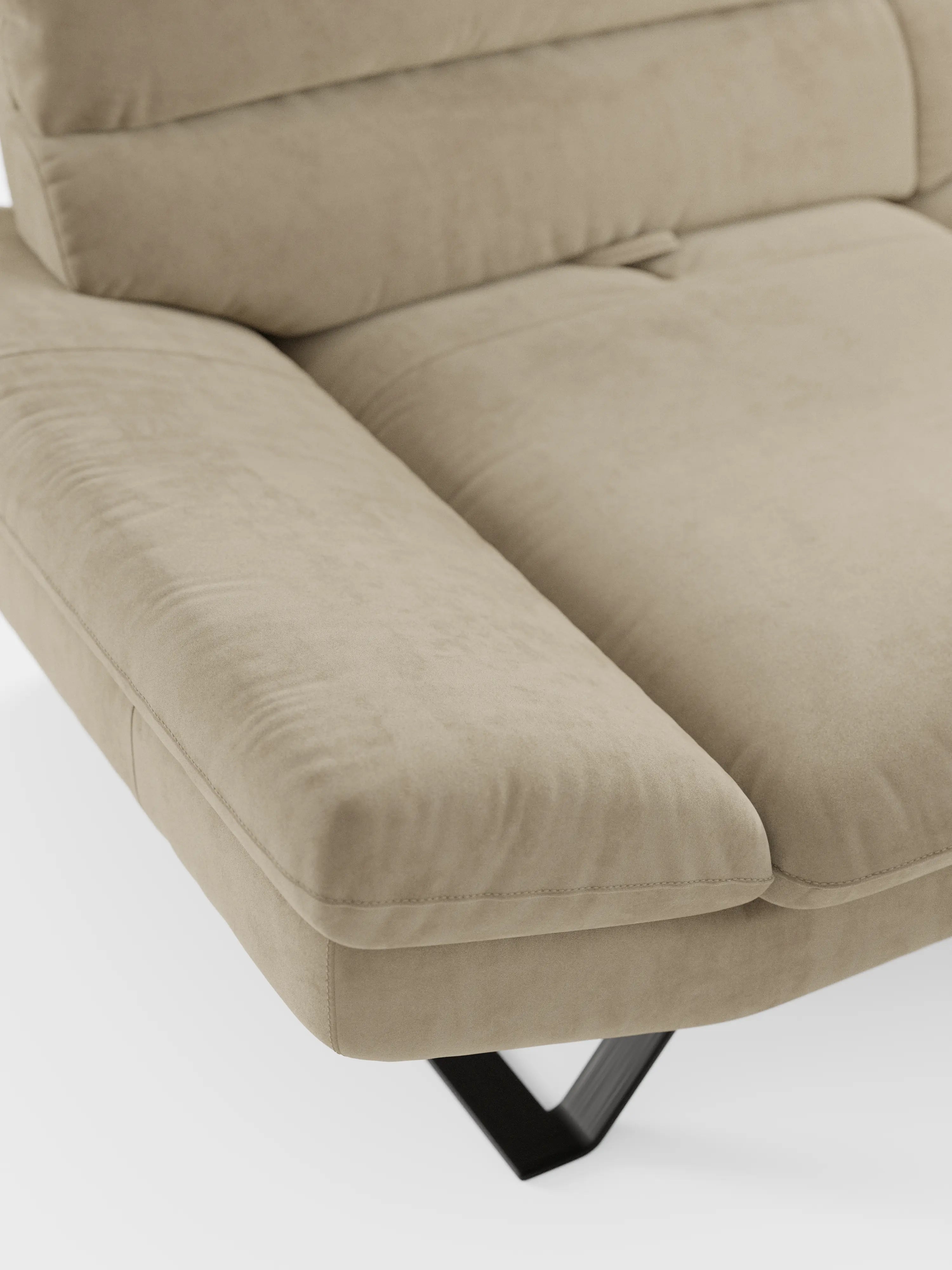 Un primo piano del divano Eclipse dal design moderno a 2 e 3 posti di Divani.Store mette in risalto la seduta e i braccioli in microfibra beige effetto pelle scamosciata, con morbidi cuscini soffici. Caratterizzato da schienali traslanti e da moderni piedini in metallo titanio, visibili nella parte inferiore, questo elegante divano risalta su uno sfondo bianco e pulito.