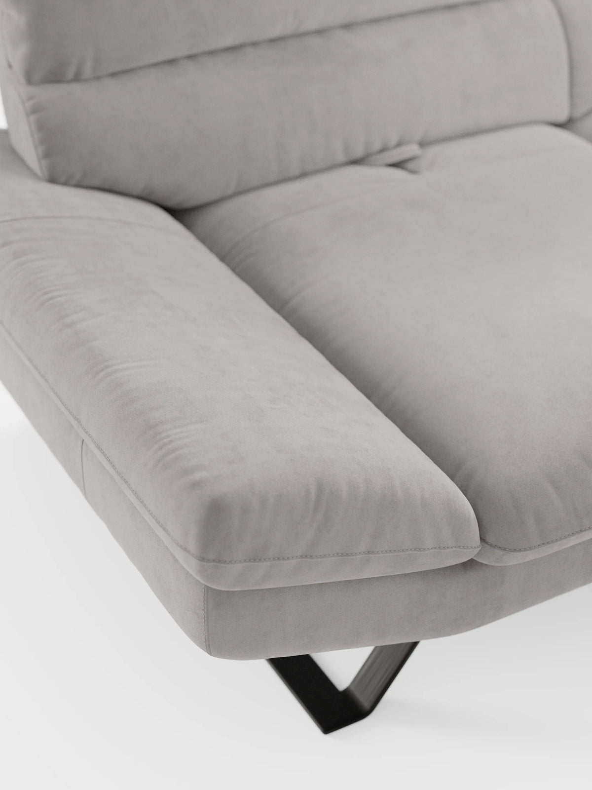 Un primo piano dell'Eclipse Divano dal design moderno di Divani.Store, rivestito in elegante microfibra T11 grigio chiaro resistente alle macchie, mostra un bracciolo insieme a una parte della seduta e dello schienale. Questo divano contemporaneo a 2 o 3 posti si caratterizza per le linee pulite e la morbida consistenza, con un alto piedino in metallo nero visibile nella parte inferiore: un elegante esempio di artigianato moderno nel campo dei divani contemporanei.