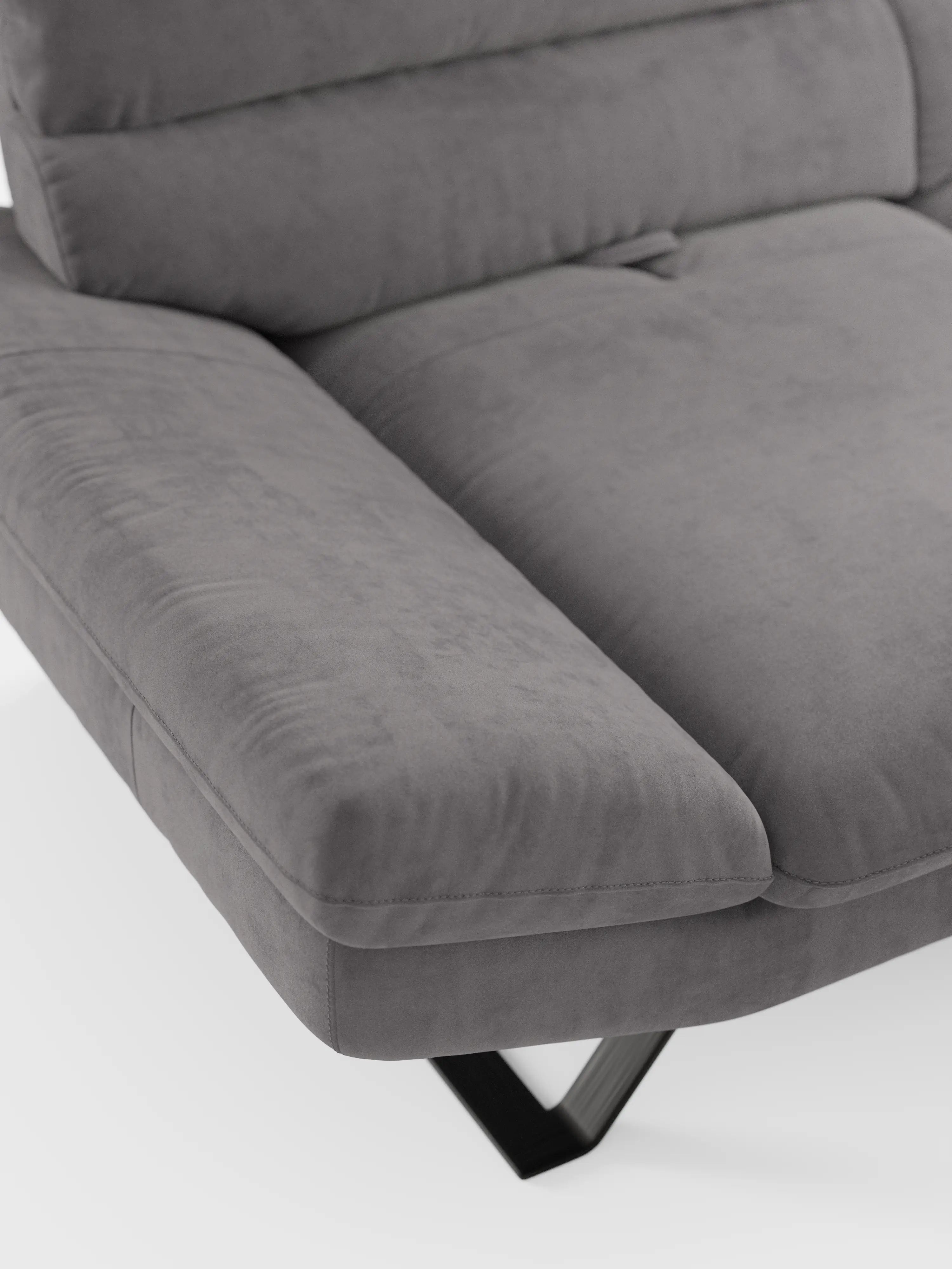 Primo piano del divano Eclipse dal design moderno a 2 e 3 posti con schienali traslanti di Divani.Store, che mette in risalto la sua imbottitura morbida, i braccioli angolati e il rivestimento in microfibra T11 smacchiabile, con texture a vista. Questo divano contemporaneo presenta eleganti gambe alte in metallo nero a forma di V ed è messo in risalto su uno sfondo bianco a tinta unita.